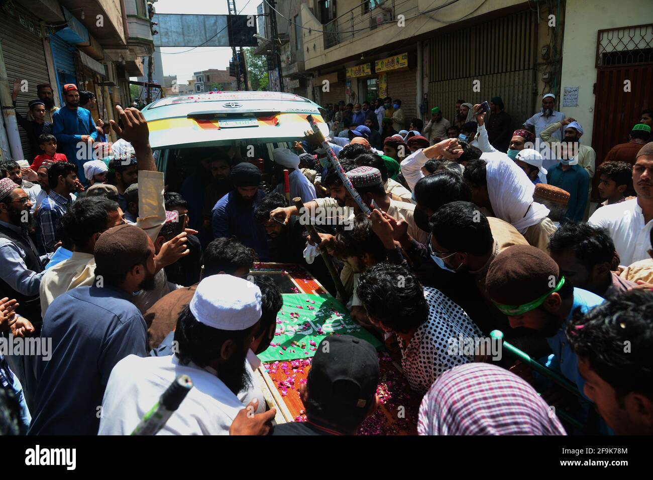 Lahore, Pakistan. 19 Apr 2021. I sostenitori del partito Tehreek-e-Labbaik Pakistan (TLP) portano la bara e gridano slogan durante la preghiera funeraria del loro collega di un compagno ucciso nello scontro domenicale con le forze di sicurezza, Una protesta dopo che il loro capo è stato arrestato a seguito del suo appello per l'espulsione dell'ambasciatore francese a Lahore. (Foto di Rana Sajid Hussain/Pacific Press) Credit: Pacific Press Media Production Corp./Alamy Live News Foto Stock