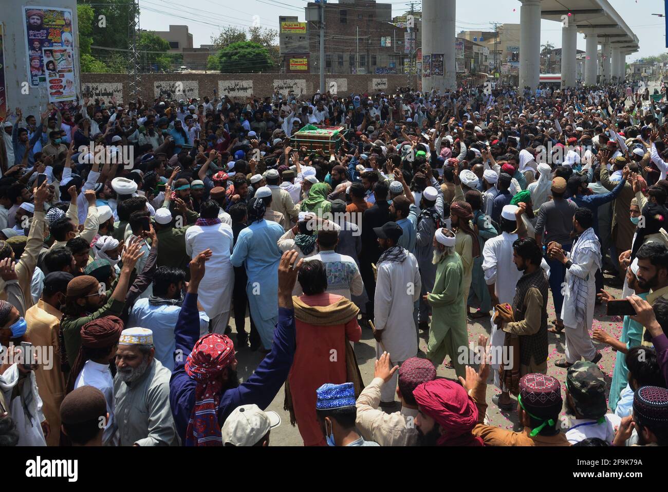 Lahore, Pakistan. 19 Apr 2021. I sostenitori del partito Tehreek-e-Labbaik Pakistan (TLP) portano la bara e gridano slogan durante la preghiera funeraria del loro collega di un compagno ucciso nello scontro domenicale con le forze di sicurezza, Una protesta dopo che il loro capo è stato arrestato a seguito del suo appello per l'espulsione dell'ambasciatore francese a Lahore. (Foto di Rana Sajid Hussain/Pacific Press) Credit: Pacific Press Media Production Corp./Alamy Live News Foto Stock