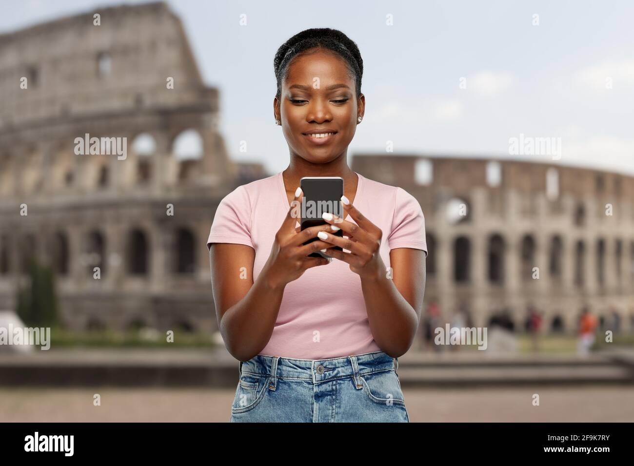 donna afroamericana con smartphone al coliseum Foto Stock