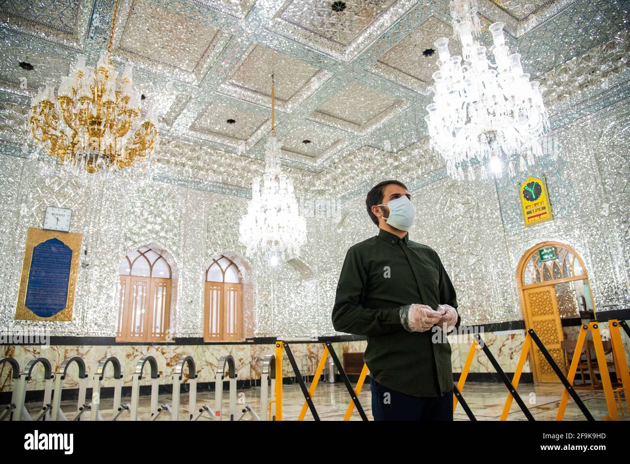 Un uomo iraniano che indossa maschera protettiva e guanti si trova vicino al santuario di Shah Abdol-Azim. (Foto di Sobhan Farajvan / Pacific Press/Sipa USA) Foto Stock