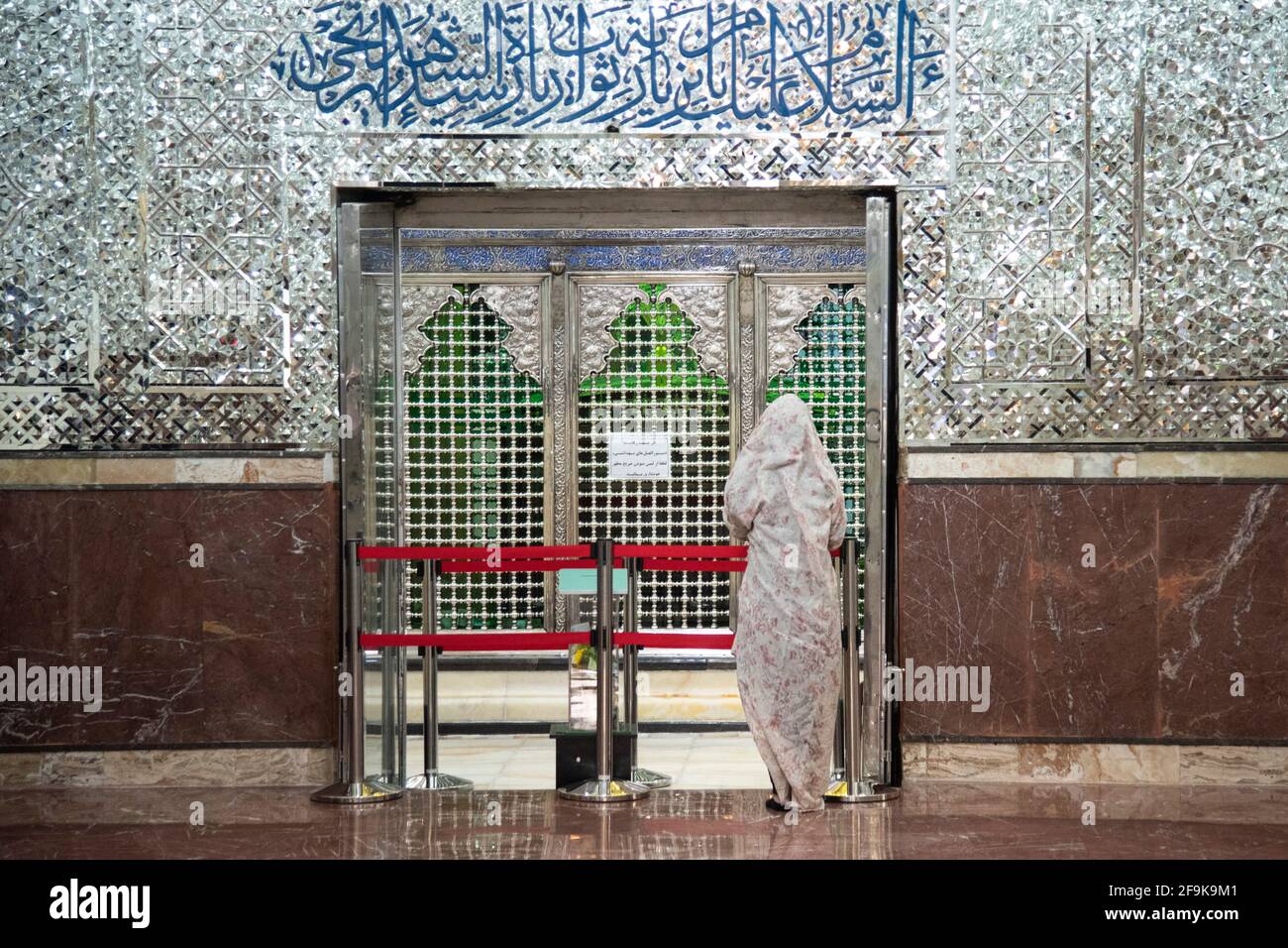 Teheran, Iran. 18 Apr 2021. Una donna si trova dietro la burocrazia e Pray.The santuario di Shah Abdol-Azim è protetto con una nastro rosso per impedire ai visitatori di toccarlo e lo scoppio COVID-19 . (Foto di Sobhan Farajvan/Pacific Press/Sipa USA) Credit: Sipa USA/Alamy Live News Foto Stock