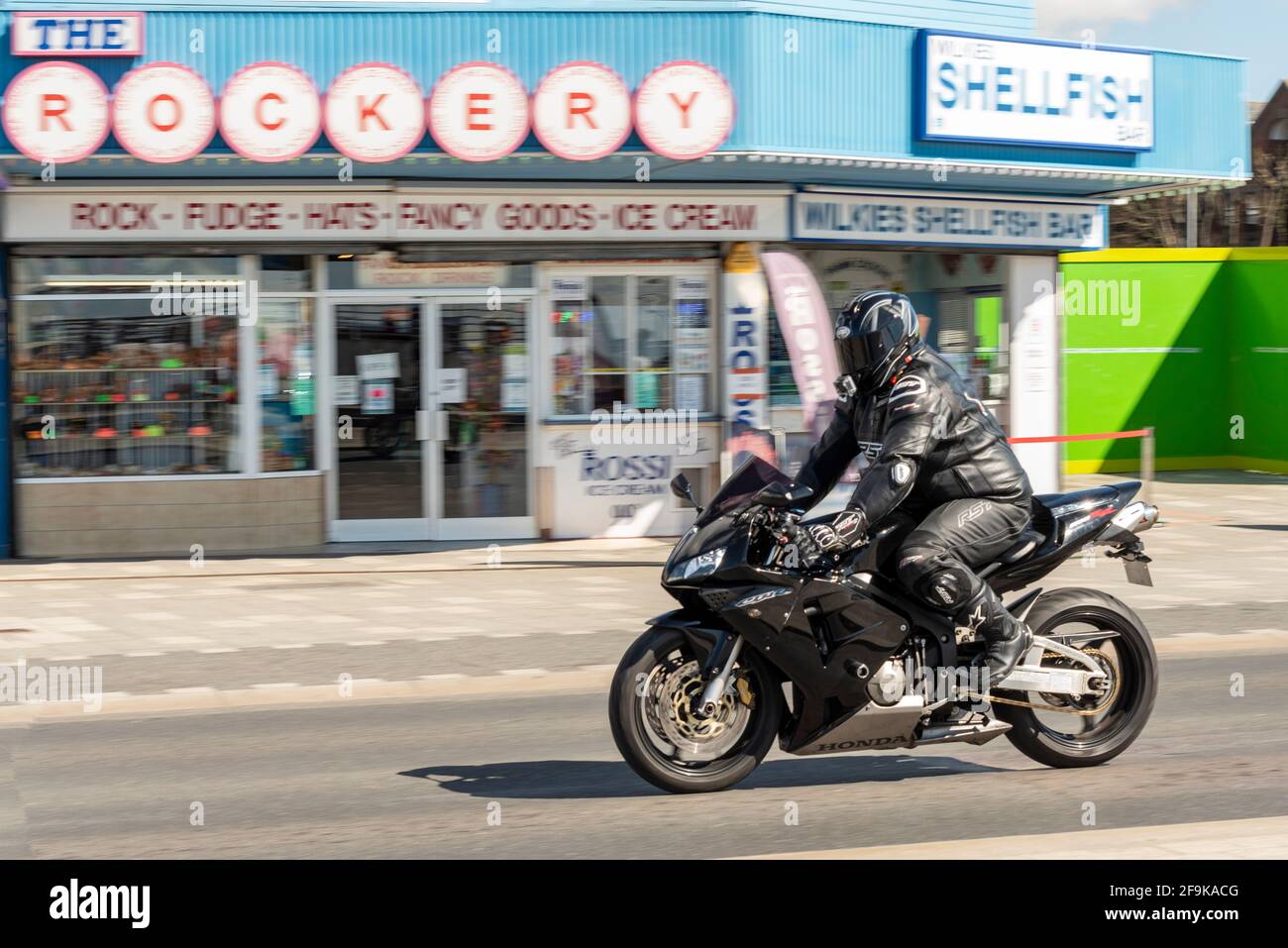 Moto Honda CBR 500RR, motociclista che corre a Southend sul mare, Essex, Regno Unito, in una soleggiata, brillante giornata primaverile. Passa accanto alla bottega di molluschi e rocce Foto Stock