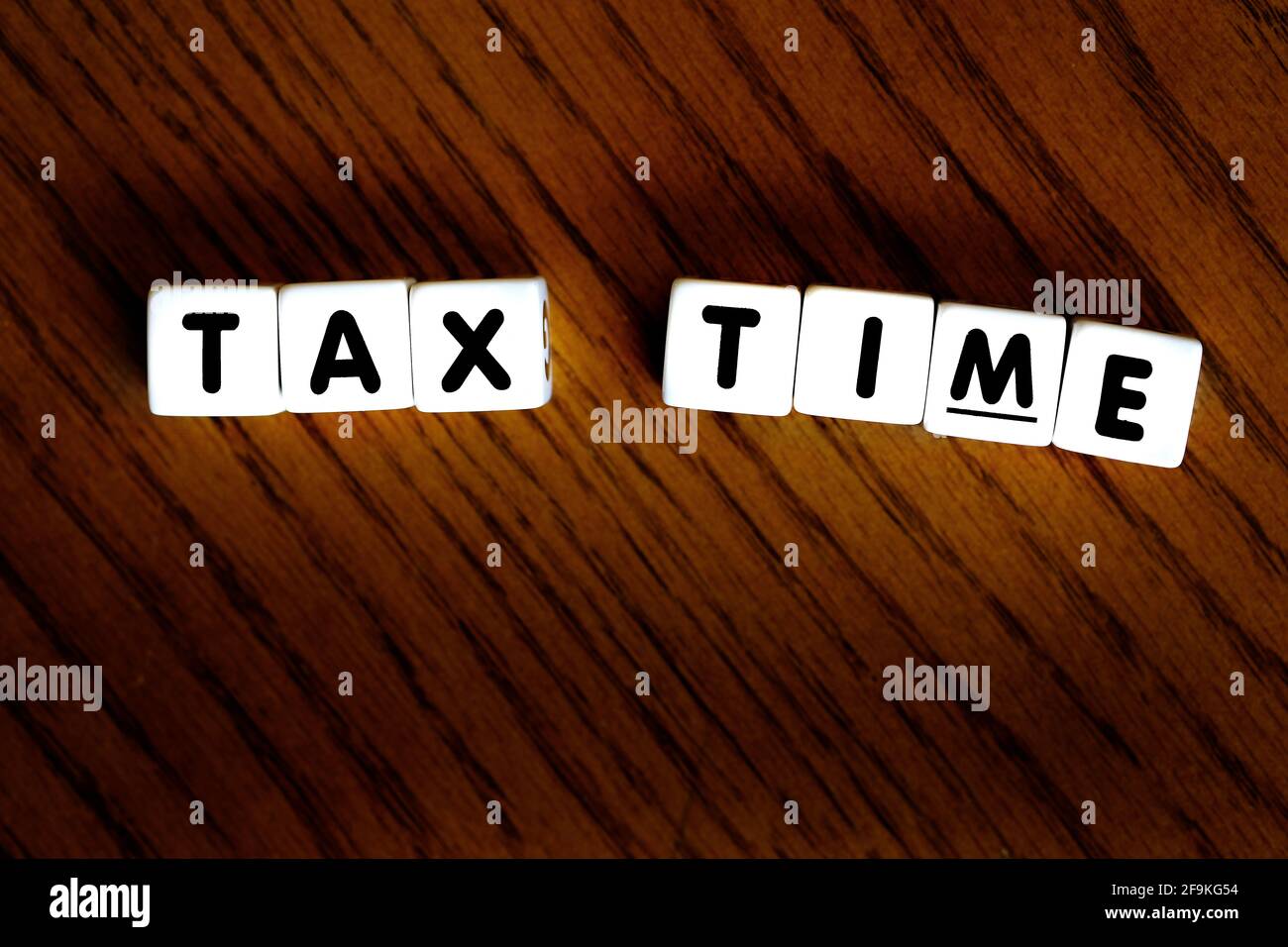 Tax time sign on wood dice block letters for IRS filings stressanti Foto Stock