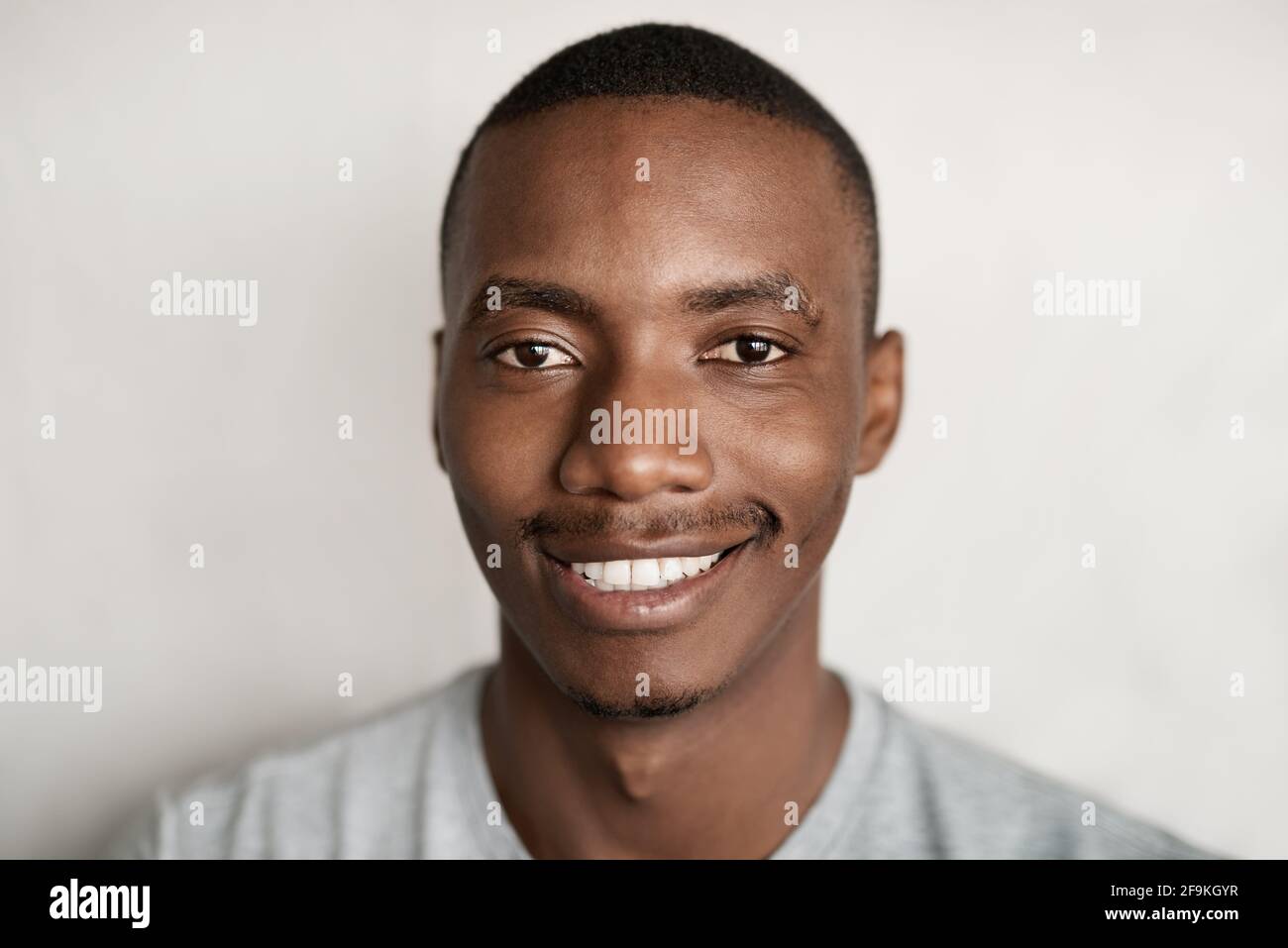 Giovane africano in una t-shirt sorridente Foto Stock