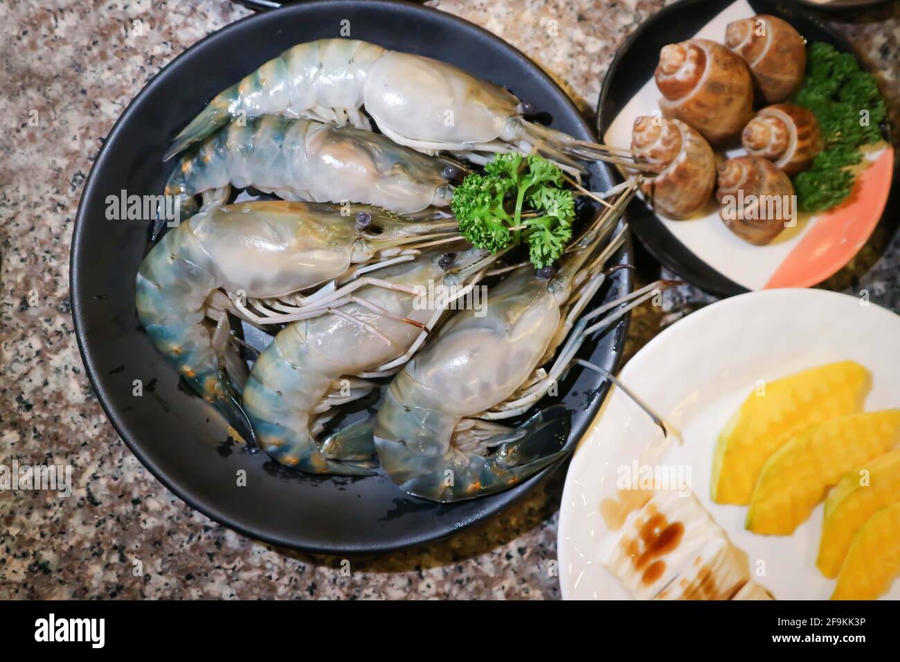 Gamberi crudi, gamberetti crudi e babilonia punteggiata o areolata Babilonia o conchiglia per cucinare Foto Stock