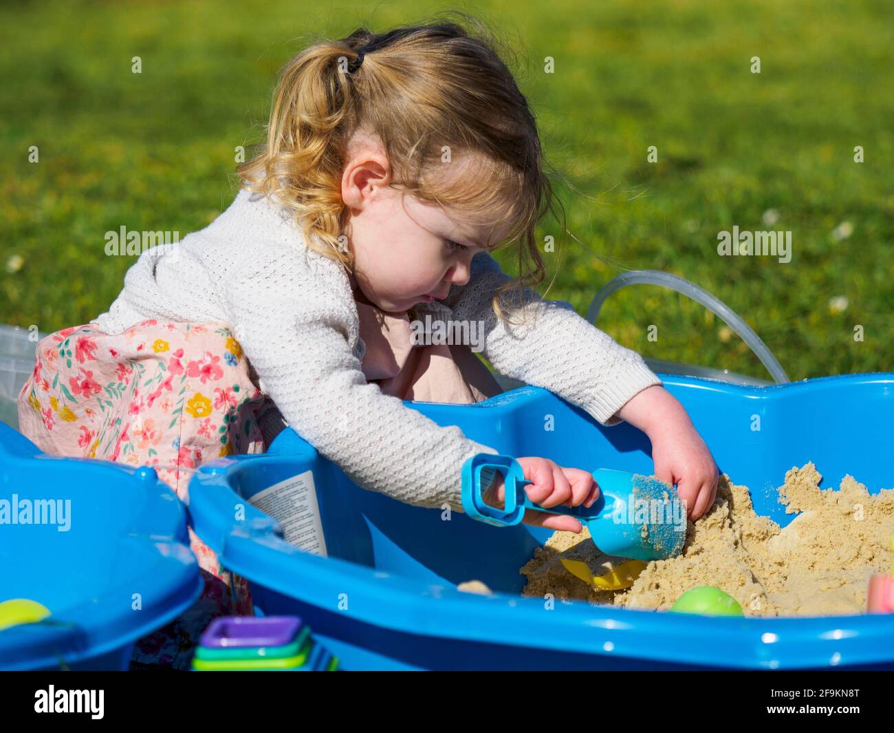 Toddler che gioca in una buca di sabbia, Regno Unito Foto Stock