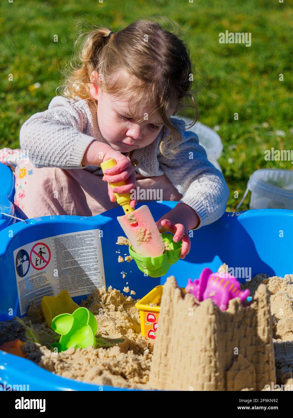 Toddler che gioca in una buca di sabbia, Regno Unito Foto Stock