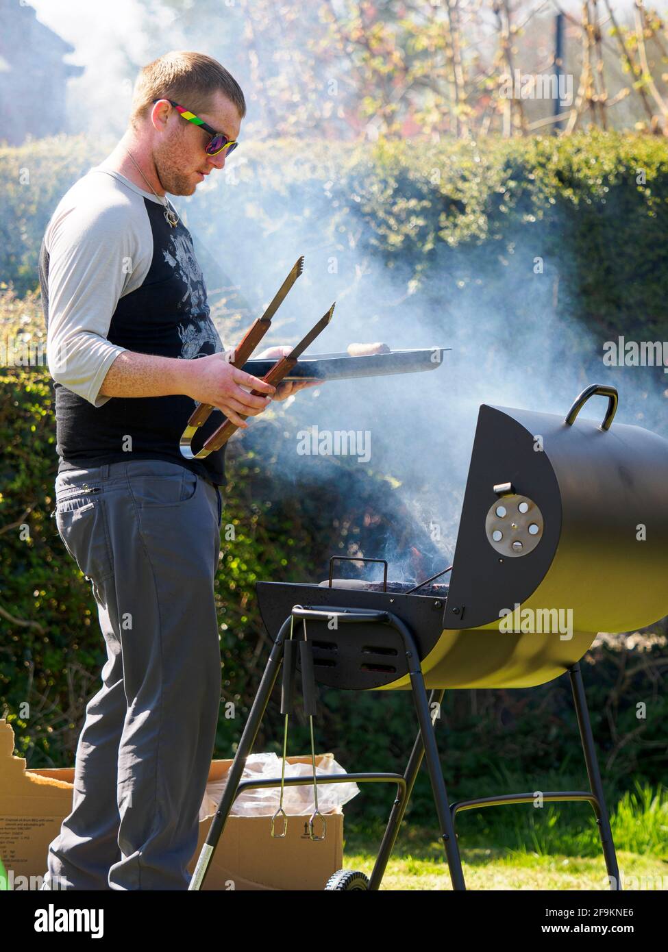 Uomo che cucina su un barbecue, Cornovaglia, Regno Unito Foto Stock