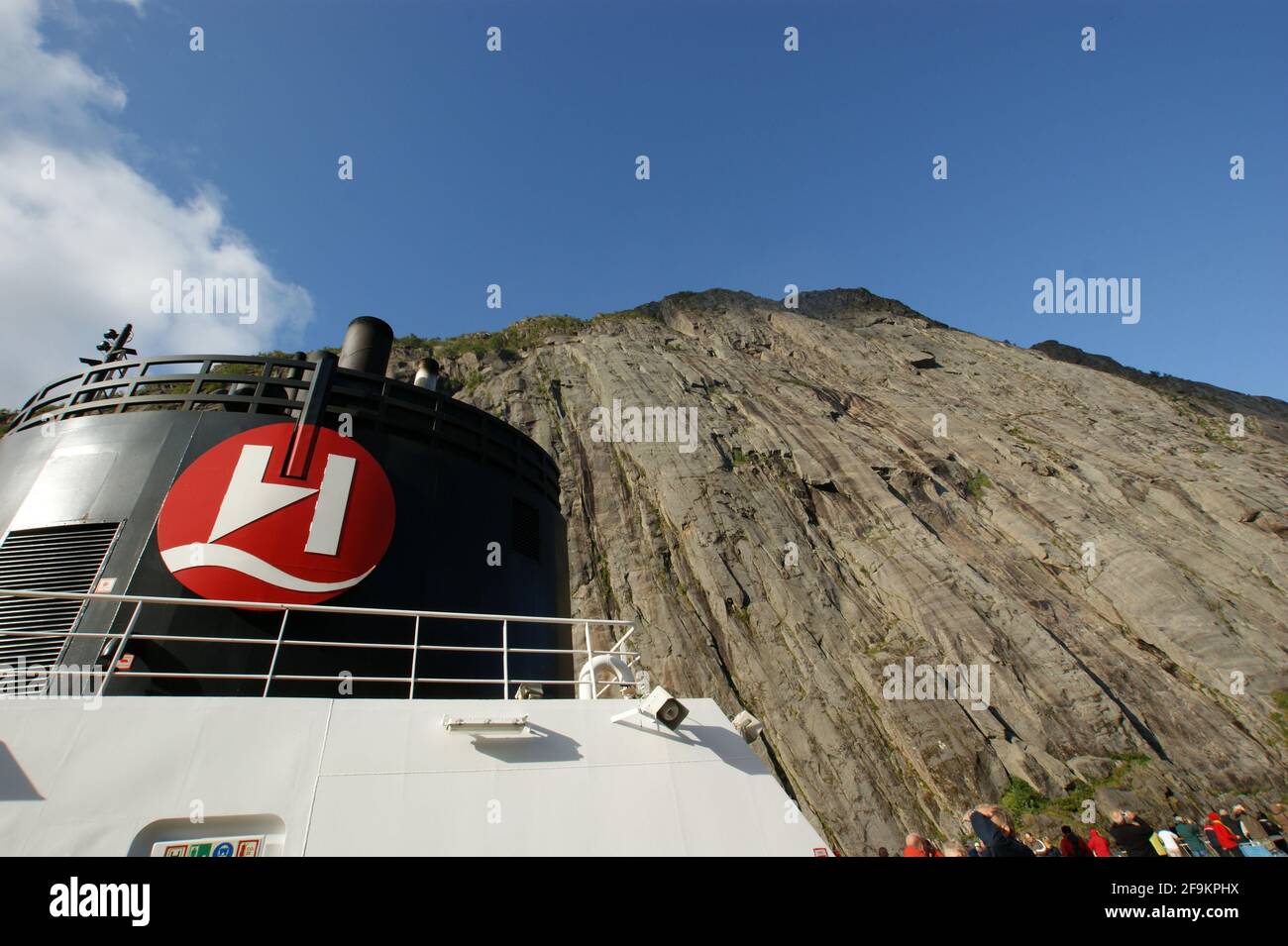 Nave da crociera Hurtigruten incurvata dalle enormi scogliere dello stretto Trollfjord che è stato introdotto attraverso una stretta apertura appena abbastanza larga da adattarsi. Foto Stock