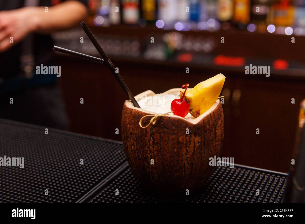 Cocktail alcolico esotico al cocco in piedi su bar tender. Foto Stock