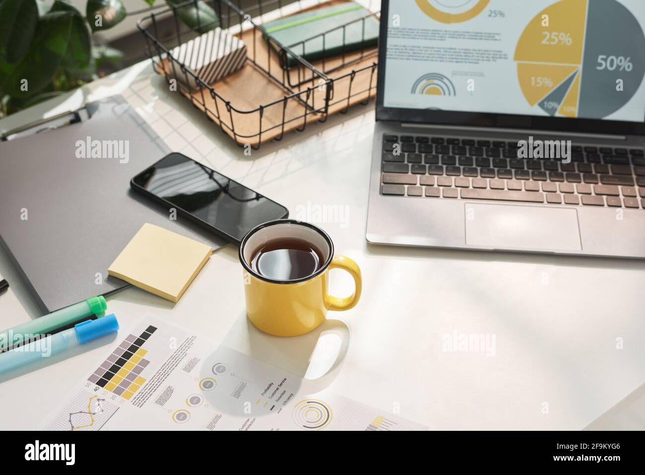 Primo piano di tavolo con computer portatile e tazza di caffè ufficio moderno Foto Stock