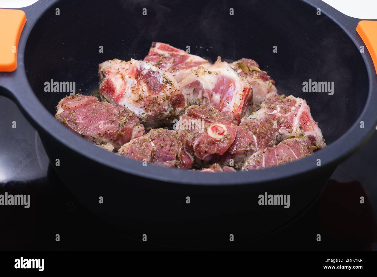Carne di agnello pronta per essere cucinata in una casseruola nera. Concetto di cucina. Foto Stock