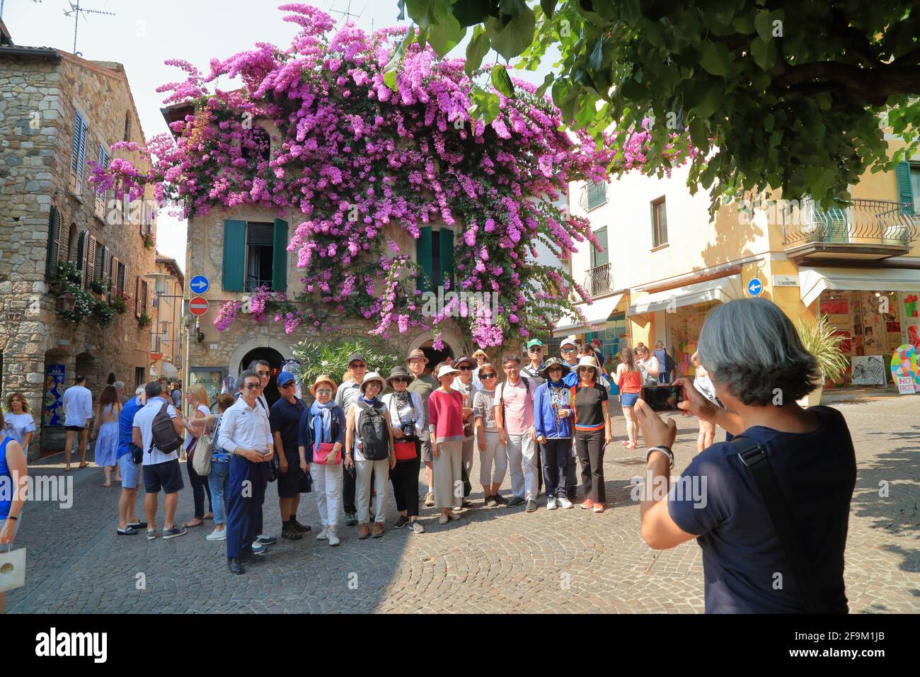 Sirmione, Lago di Garda. Fiori viola bouganvillea a casa della città vecchia. Lago di Garda, Gardasee, Italia Foto Stock