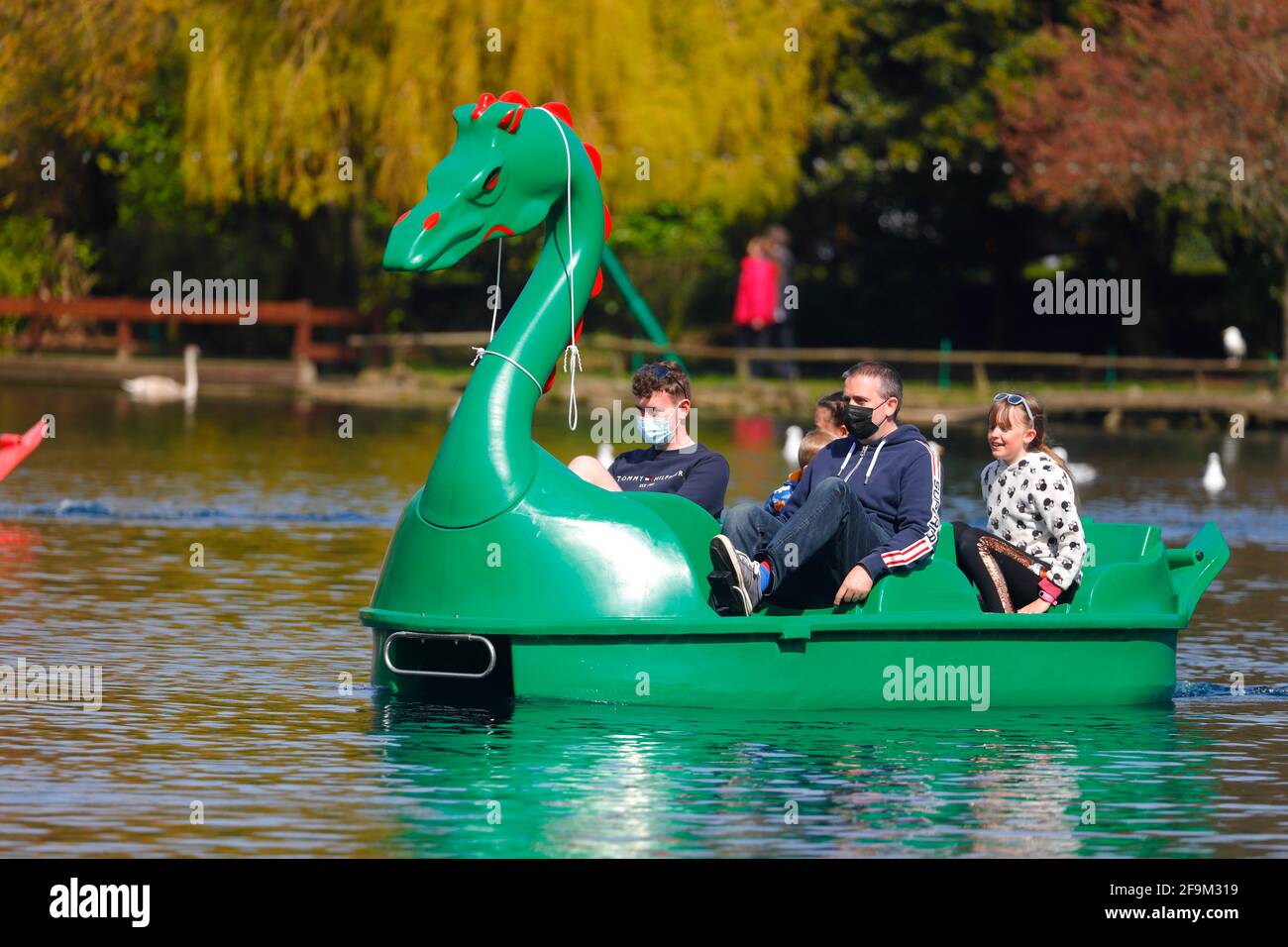 Turisti che indossano rivestimenti per il viso per proteggersi da Covid ON Un pedalo drago al Peasholm Park a Scarborough, North Yorkshire, UK Foto Stock