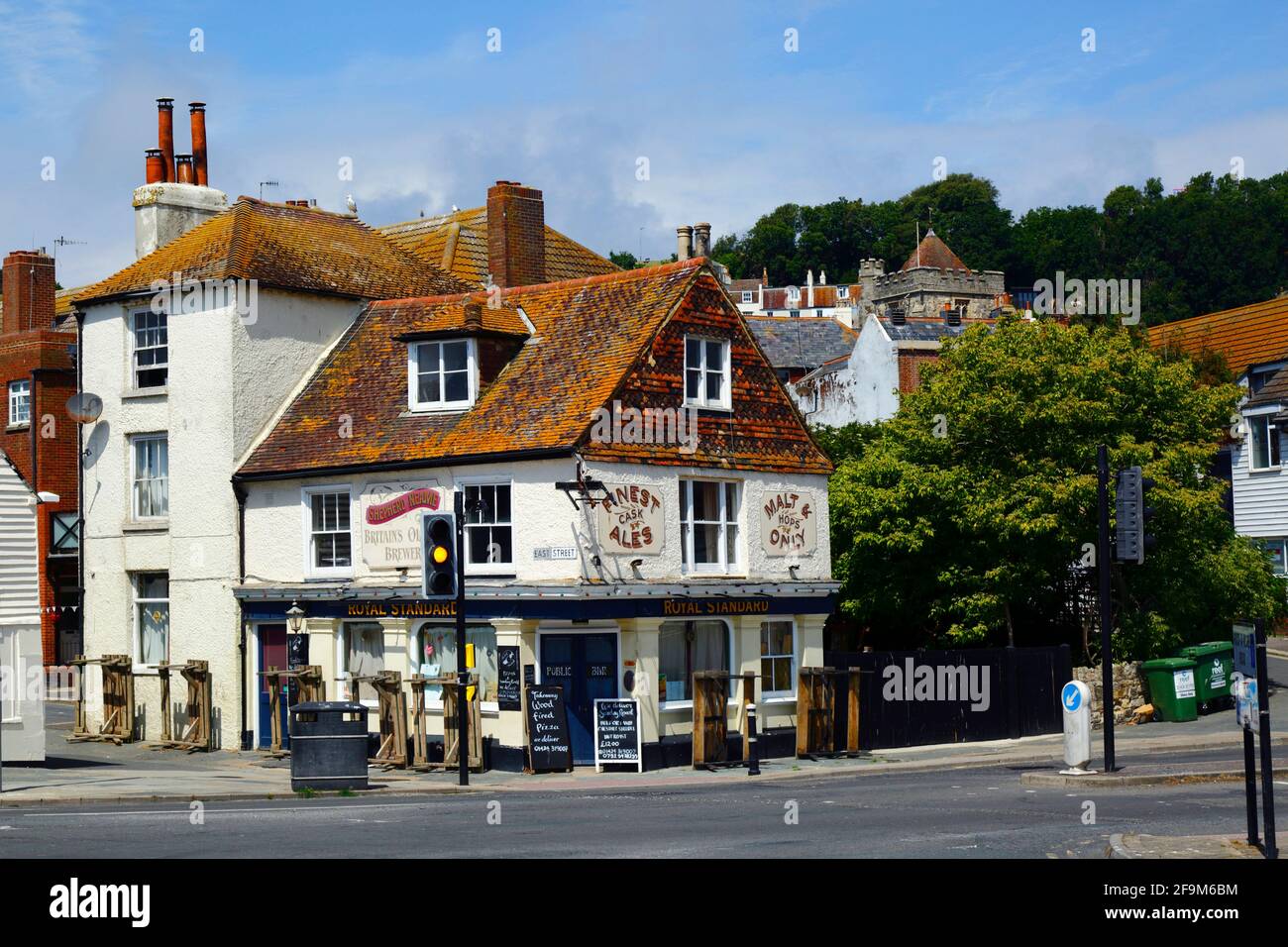 Il pub Royal Standard sulla strada principale A259 in fondo alla Bourne nella città vecchia, la torre della chiesa di St Clements in background, Hastings, East Sussex, Inghilterra Foto Stock