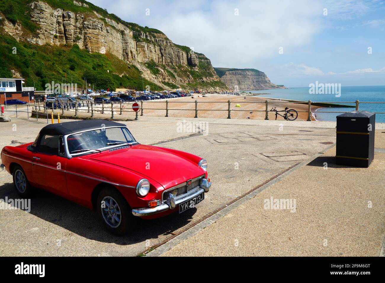 Auto classica Red MG MGB nel parcheggio Rock-A-Nore, East Cliffs in background, Hastings, East Sussex, Inghilterra, Regno Unito Foto Stock