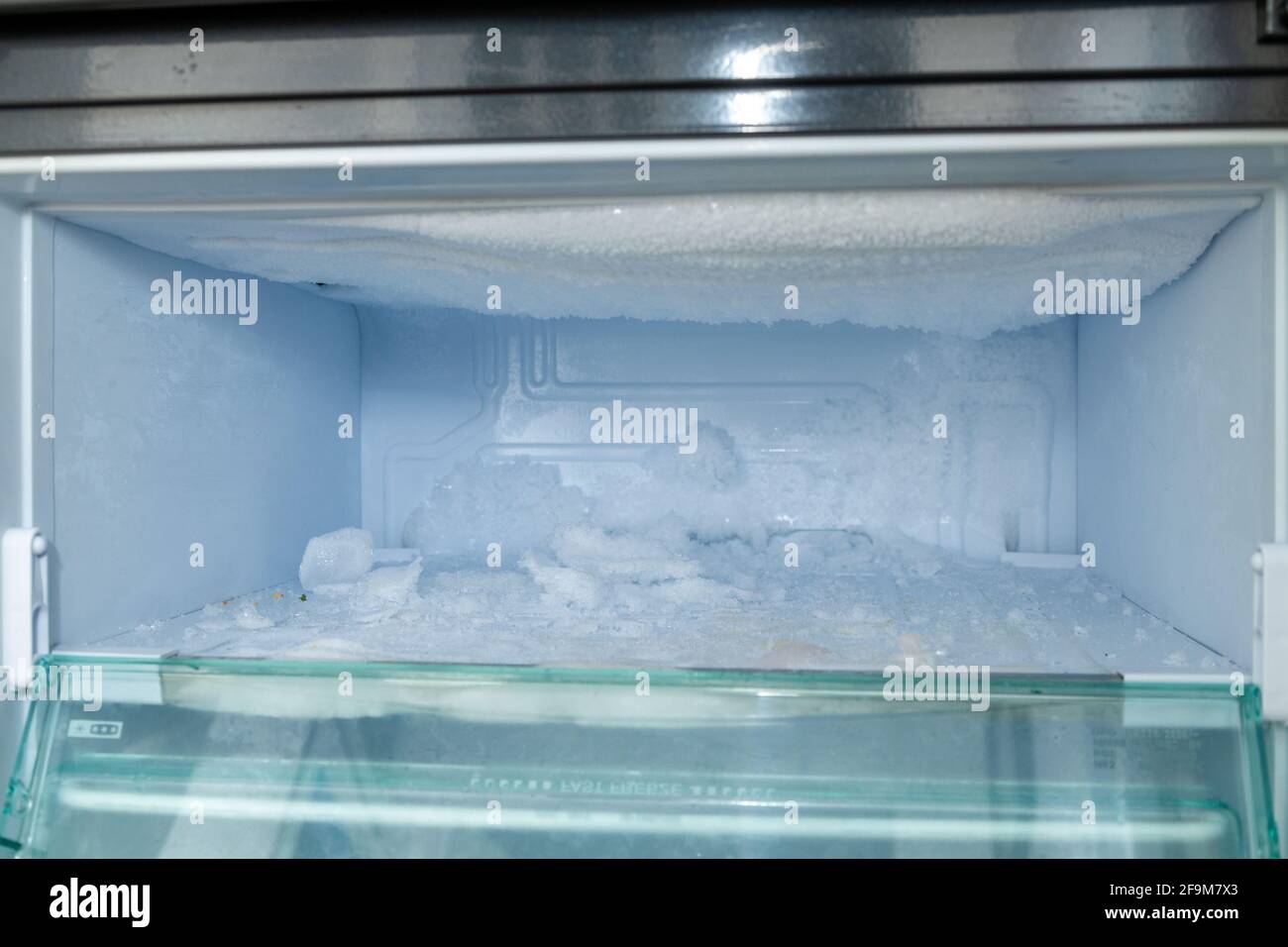Sbrinamento di un congelatore con accumulo di ghiaccio Foto Stock
