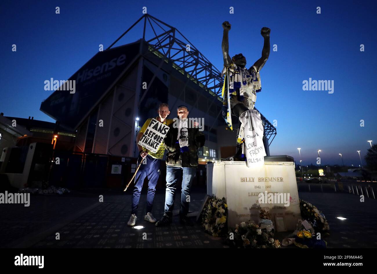 I fan di Leeds United, accanto alla statua dell'ex giocatore di Leeds United Billy Bremner, protestano contro la decisione di Liverpool di essere incluso tra i club che tentano di formare una nuova Super League europea. Durante la partita della Premier League a Elland Road, Leeds. Data immagine: Lunedì 19 aprile 2021. Foto Stock