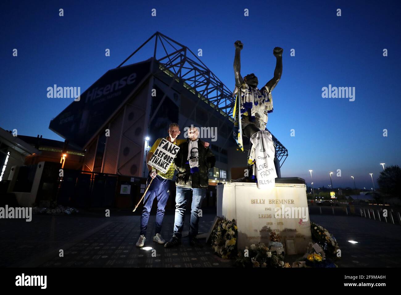 I fan di Leeds United, accanto alla statua dell'ex giocatore di Leeds United Billy Bremner, protestano contro la decisione di Liverpool di essere incluso tra i club che tentano di formare una nuova Super League europea. Durante la partita della Premier League a Elland Road, Leeds. Data immagine: Lunedì 19 aprile 2021. Foto Stock