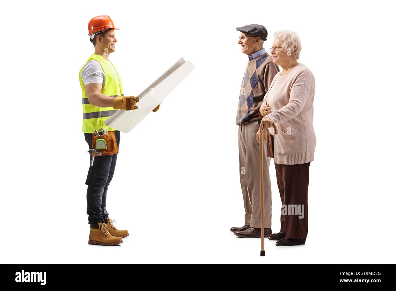 Scatto di profilo di lunghezza completa di un lavoratore di costruzione che tiene un blueprint e parlare con una coppia anziana isolata su bianco sfondo Foto Stock