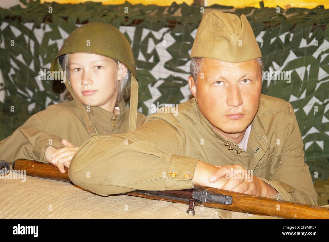 Padre e figlia in uniforme militare seduti in una trincea Foto Stock