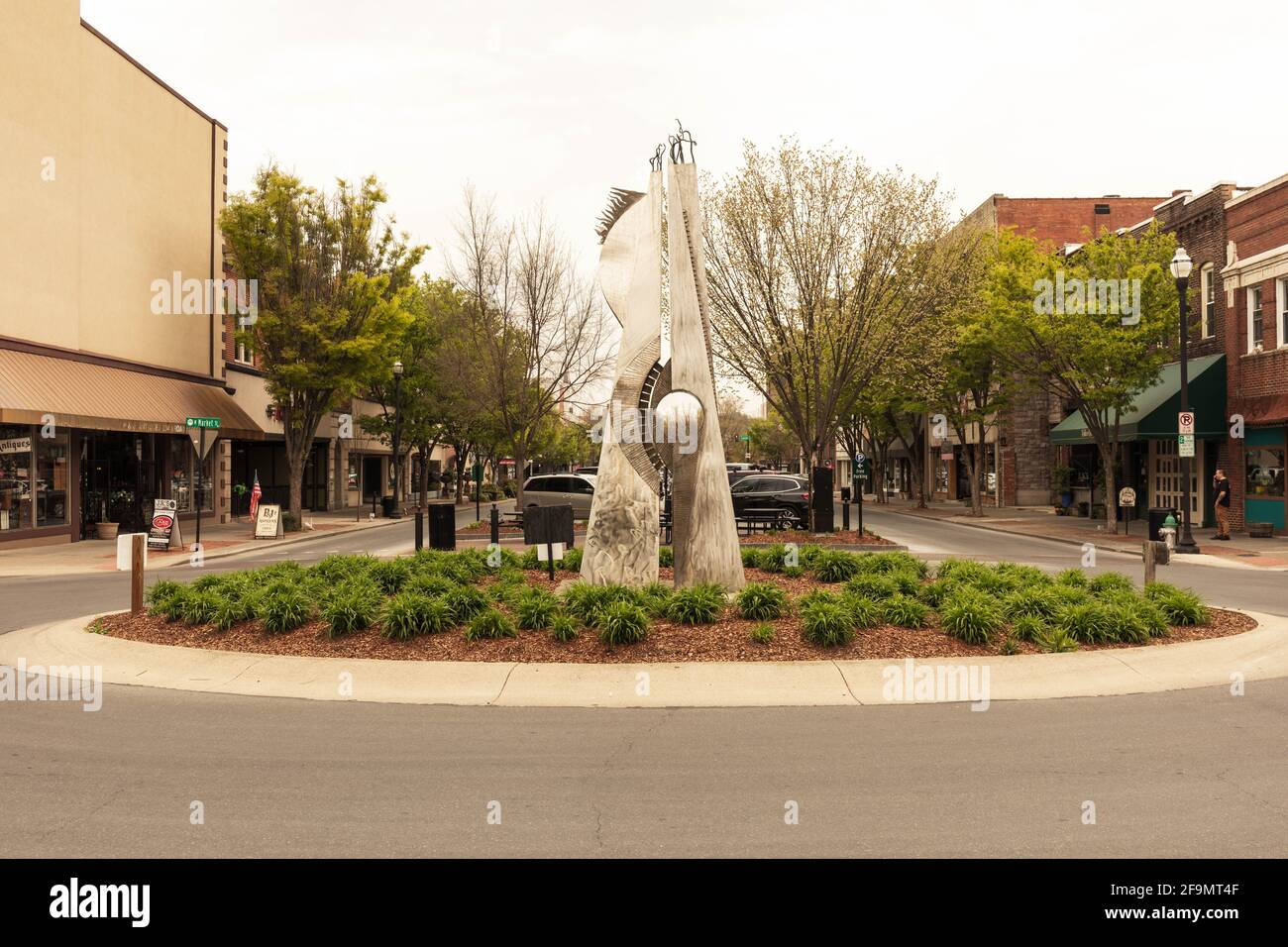 KINGSPORT, TN, USA--8 APRILE 2021: Vista della strada principale con negozi, parkinig e una grande scultura al centro della rotonda chiamata 'i quattro elementi', Foto Stock