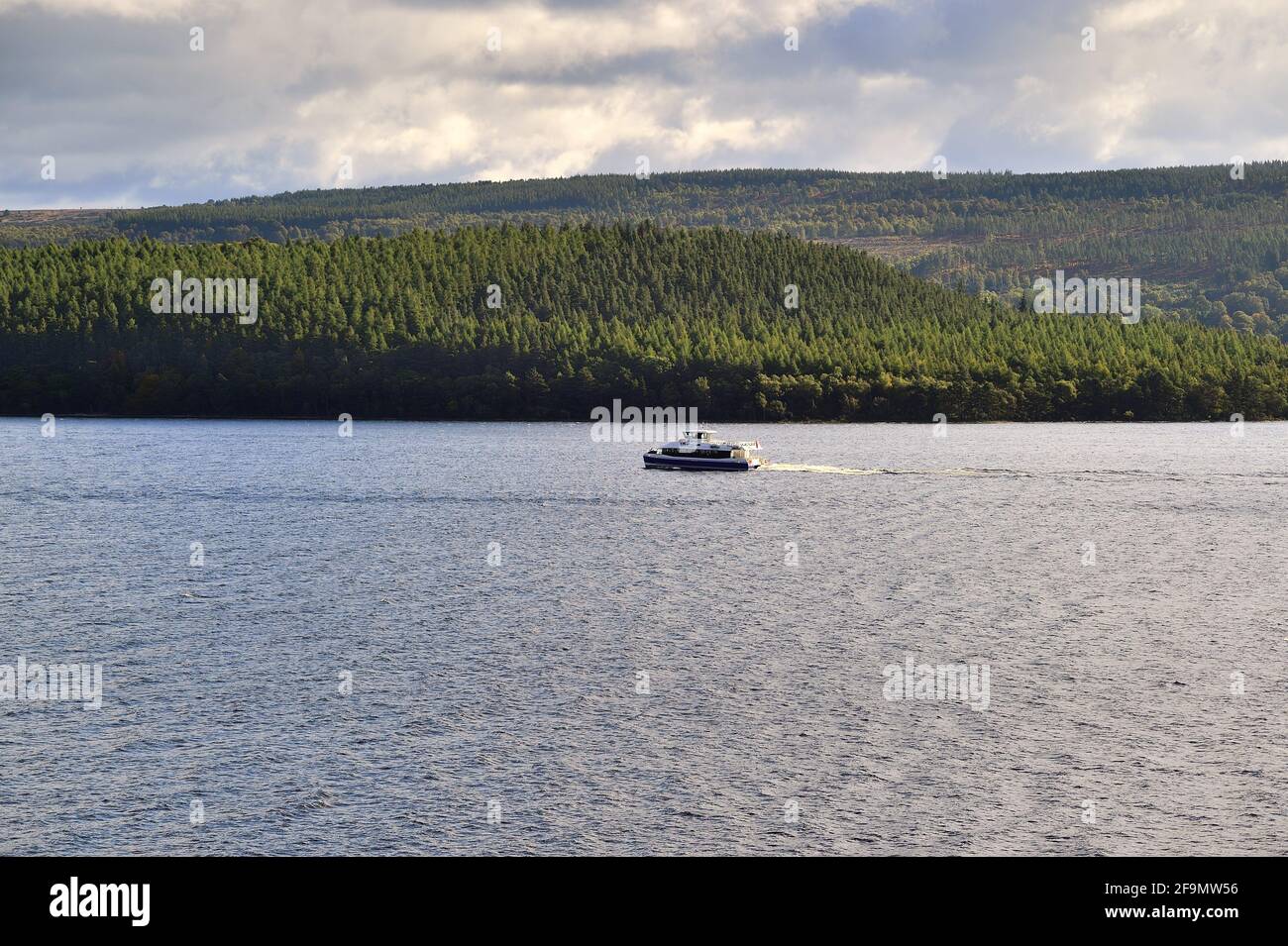 Drumnadrochit, Scozia, Regno Unito. Un'unica barca che negozia le acque di Loch Ness all'interno delle Highlands. Foto Stock