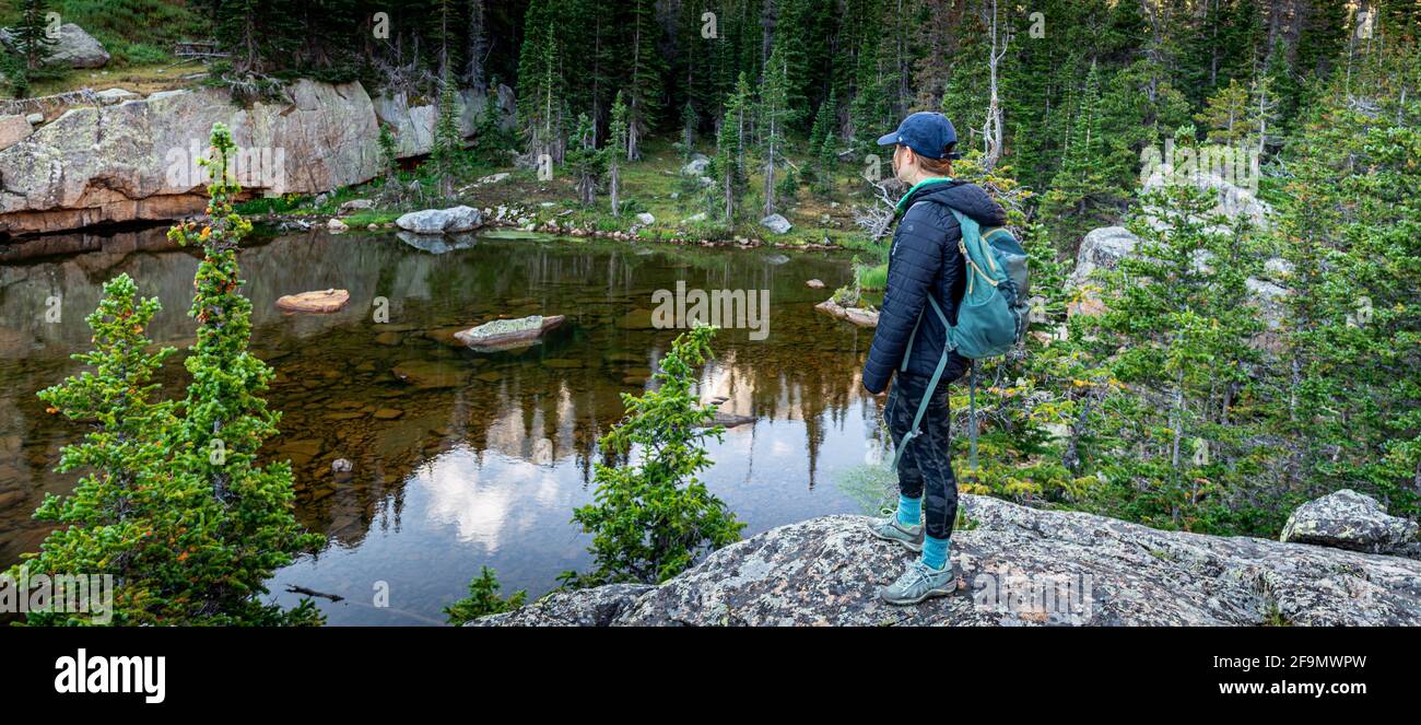 Escursionista che guarda verso il lago embrione con Taylor Peak in la distanza lontana Foto Stock