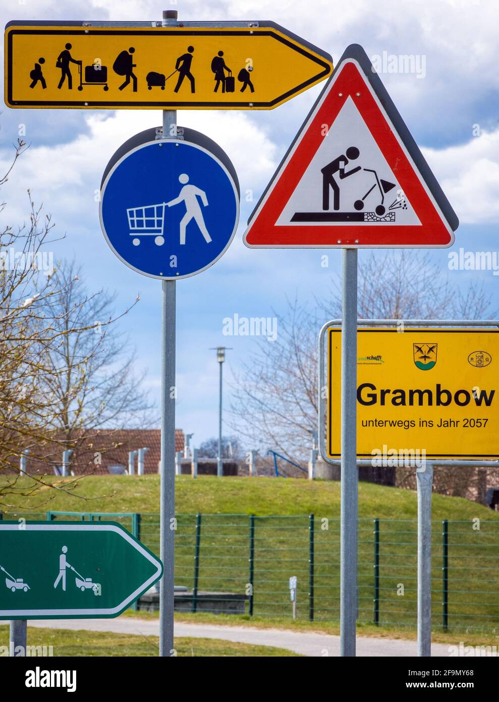 15 aprile 2021, Meclemburgo-Pomerania occidentale, Grambow: Segnali stradali del futuro stand come un progetto artistico del gruppo di artisti 'Reinigungsgesellschaft' (Martin Keil e Henrik Mayer) nel centro del paese. Gli artisti di Dresda hanno sviluppato un "sistema di guida per il nuovo Grambow 2057", che visualizza le idee e i suggerimenti per una migliore vita rurale in pittogrammi colorati. Il contenuto è il villaggio di Grambow nel 2057, quando il villaggio avrà 700 anni. Dodici segnali stradali in lamiera zincata si occupano di questioni come il cambiamento climatico, lo sviluppo demografico, l'occupazione, AN Foto Stock