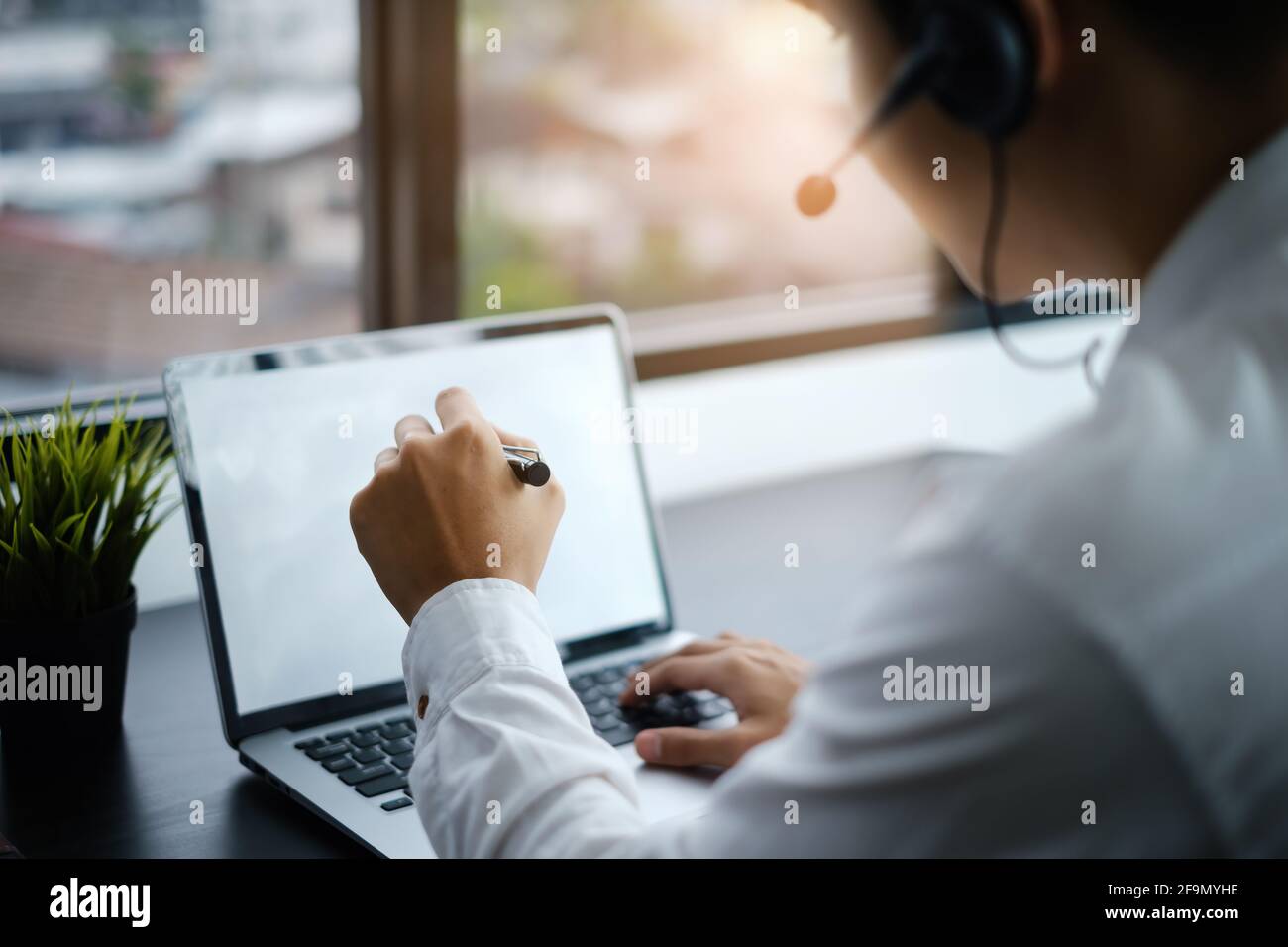 DURANTE il fine settimana delle feste. Responsabile dell'assistenza o Call center nella consulenza sulle cuffie/auricolari, consiglia un cliente 24 ore su 24. Foto Stock