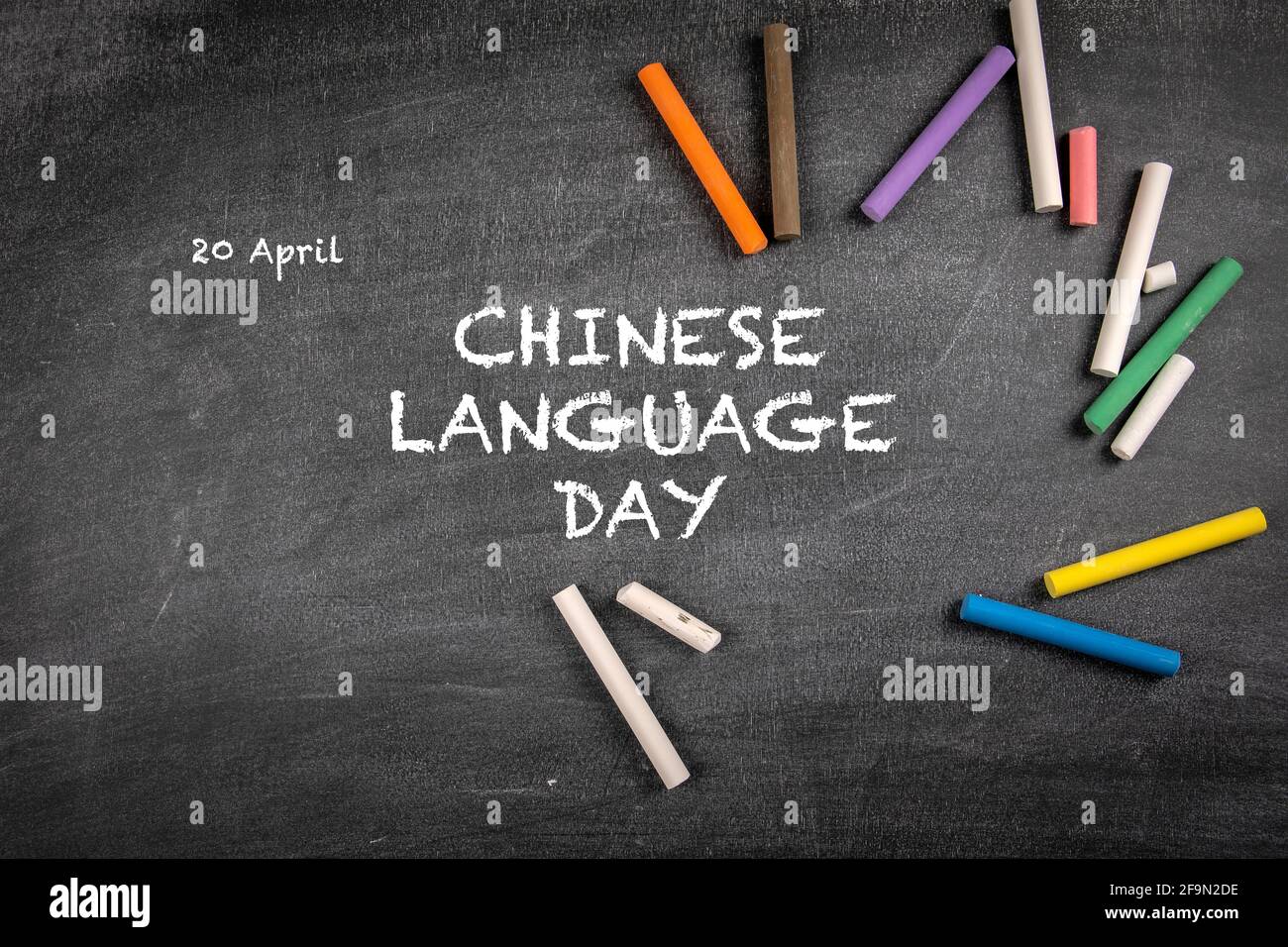 Giornata della lingua cinese 20 aprile. Pezzi colorati di gesso su uno sfondo di una tavola di gesso scuro. Foto Stock