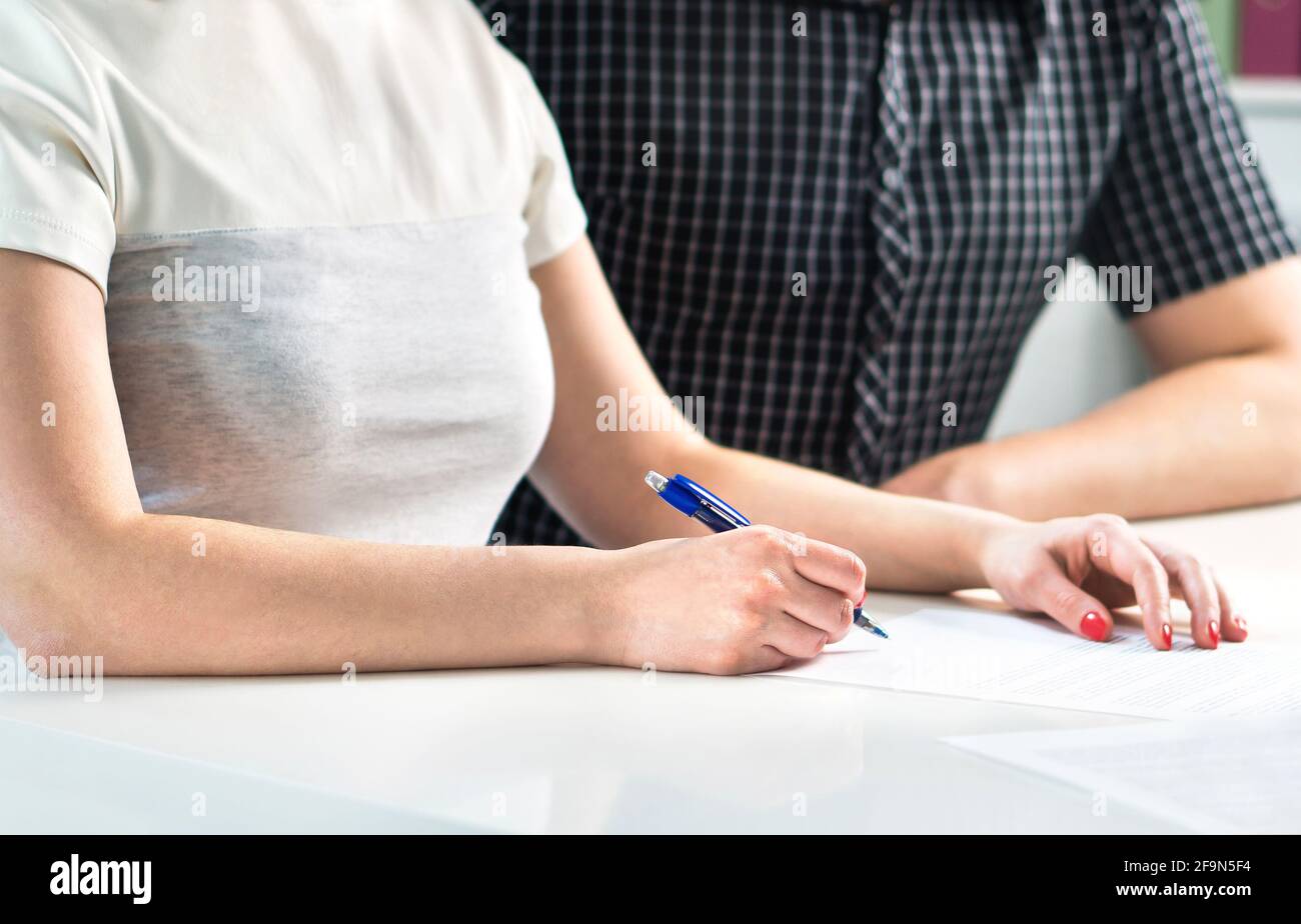 Coppia che scrive un programma, contando il preventivo della famiglia o firmando il contratto di liquidazione. Moglie e marito che fanno la lista di controllo, organizzazione futura insieme. Foto Stock