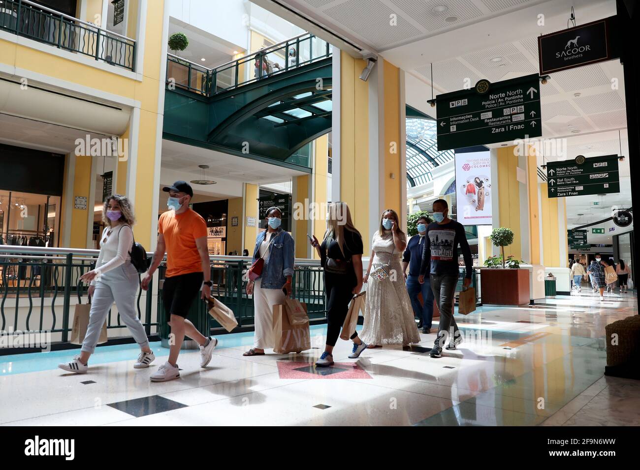 Lisbona, Portogallo. 19 Apr 2021. La gente va a fare shopping al centro commerciale Colombo riaperto a Lisbona, Portogallo, il 19 aprile 2021. Il Portogallo ha proceduto lunedì alla terza fase di definamento, o di allentamento delle misure di blocco COVID-19, con la graduale riapertura di servizi e altre attività nei comuni con un tasso di incidenza COVID-19 relativamente basso. Nella maggior parte del paese, le scuole hanno ripreso l'istruzione di persona e i negozi, i centri commerciali e i ristoranti hanno riaperto con restrizioni di occupazione e le misure di salute e sicurezza nei punti vendita. Credit: Pedro Feuza/Xinhua/Alamy Live News Foto Stock