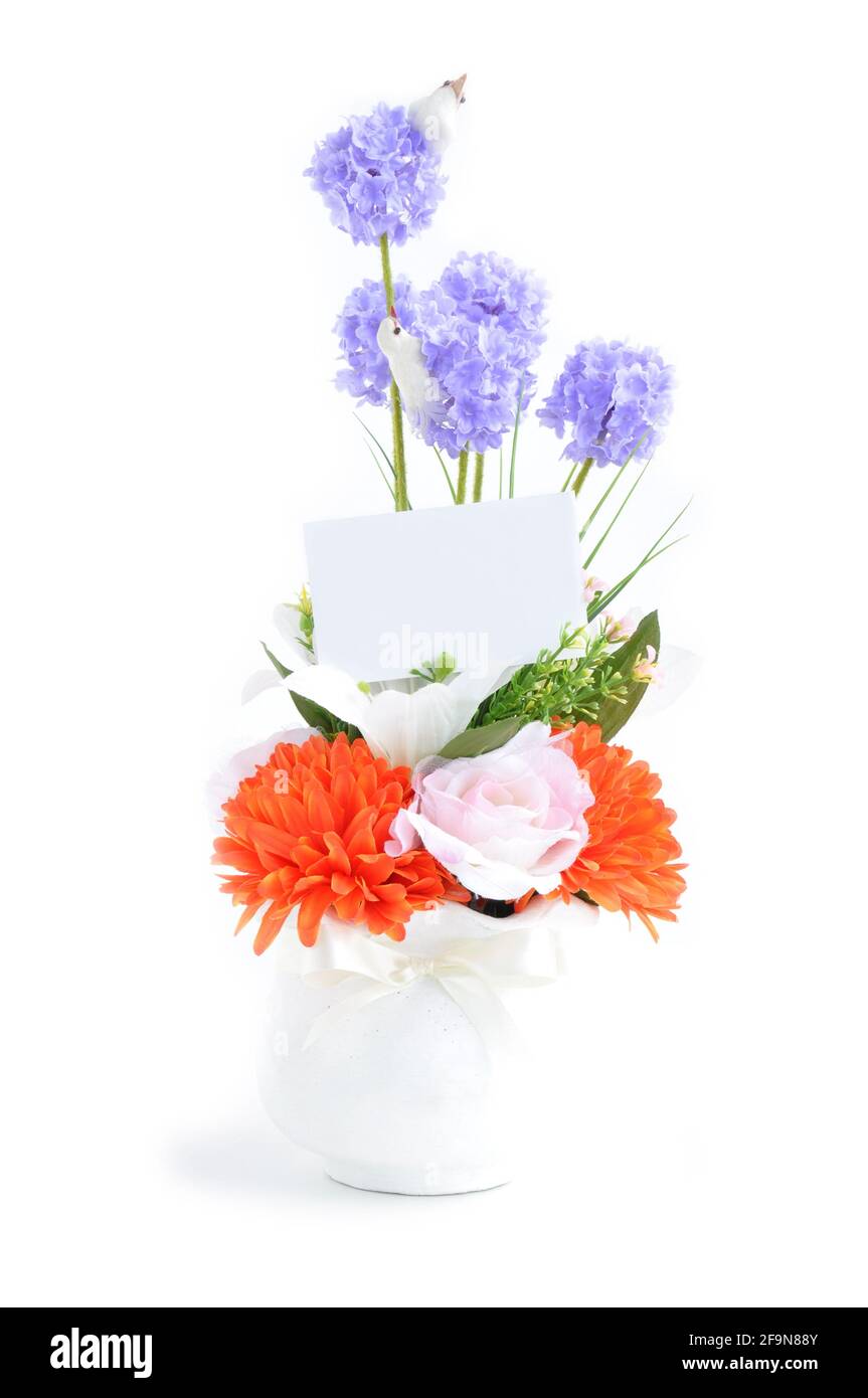 Bouquet di fiori artificiali in vaso bianco con cartoncino vuoto - isolato Foto Stock