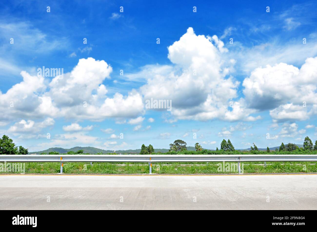 Splendida vista sulla strada con verde natura e cielo blu sfondo Foto Stock