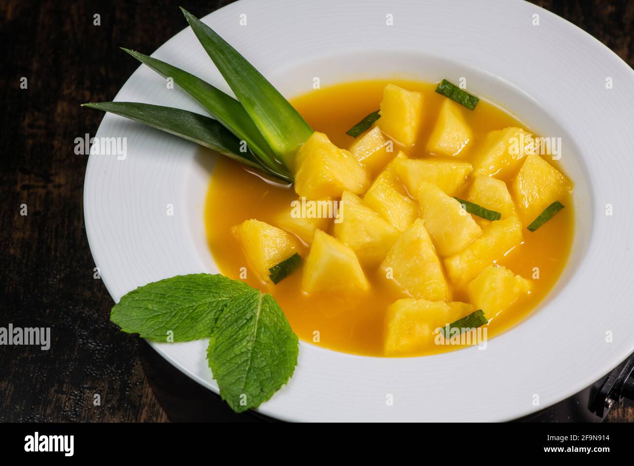 Ricetta dolce di ananas fresco con coulis di arancia alla menta Foto stock  - Alamy