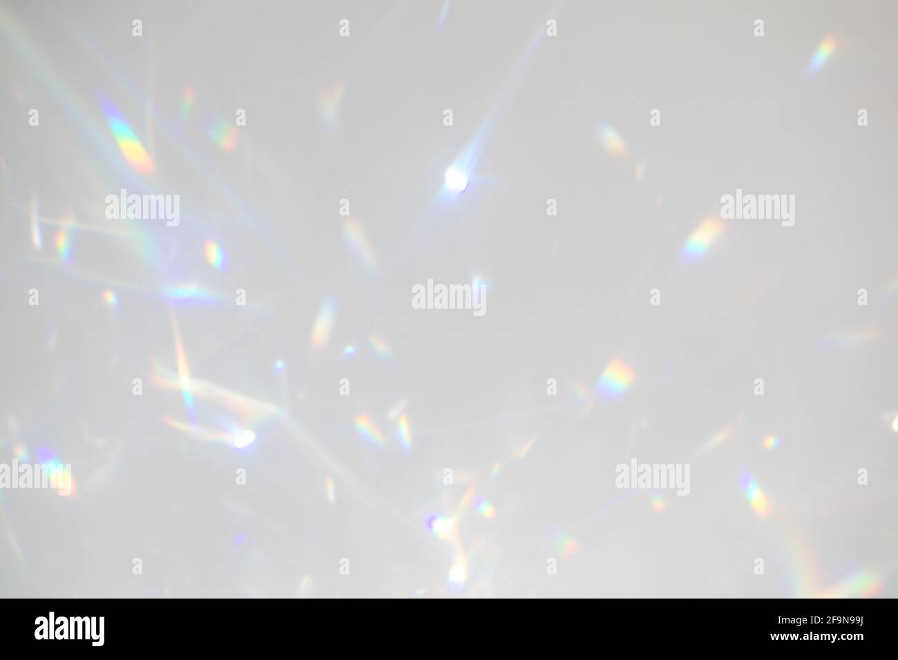 Rifrazione della luce arcobaleno sfocata sulla parete bianca Foto Stock
