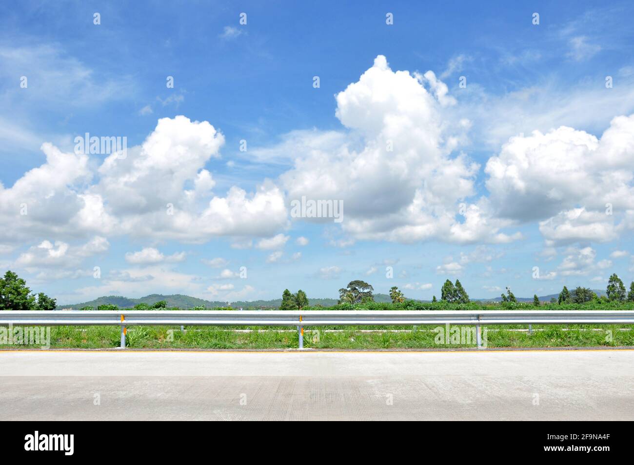 Bella vista sulla strada con verde natura e cielo blu nuvoloso bachground Foto Stock