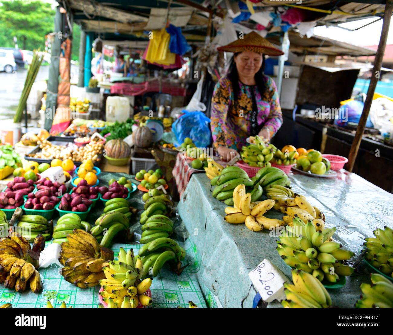 Un venditore malese di banane al mercato colorato a Miri, Malesia. Foto Stock