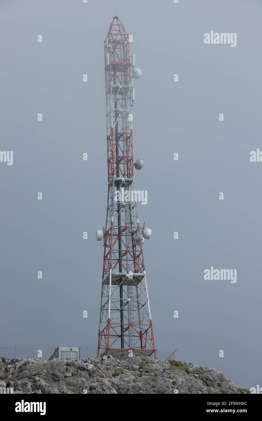 Vista dal suolo delle torri di telecomunicazione nelle nuvole su una vetta di montagna sull'isola di Creta. Foto Stock