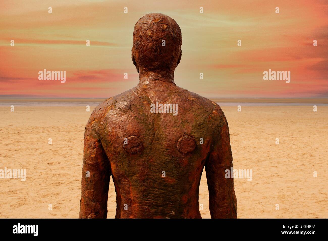 un altro luogo anthony gormley ferro uomo scultura al tramonto spiaggia di crosby vicino a liverpool inghilterra Foto Stock