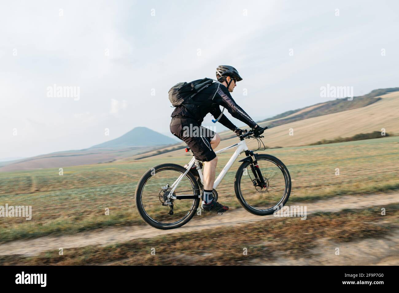 Uomo mountain bike su pista sterrata. Bicicletta ciclistica lungo la strada sterrata in una giornata di sole. Foto Stock