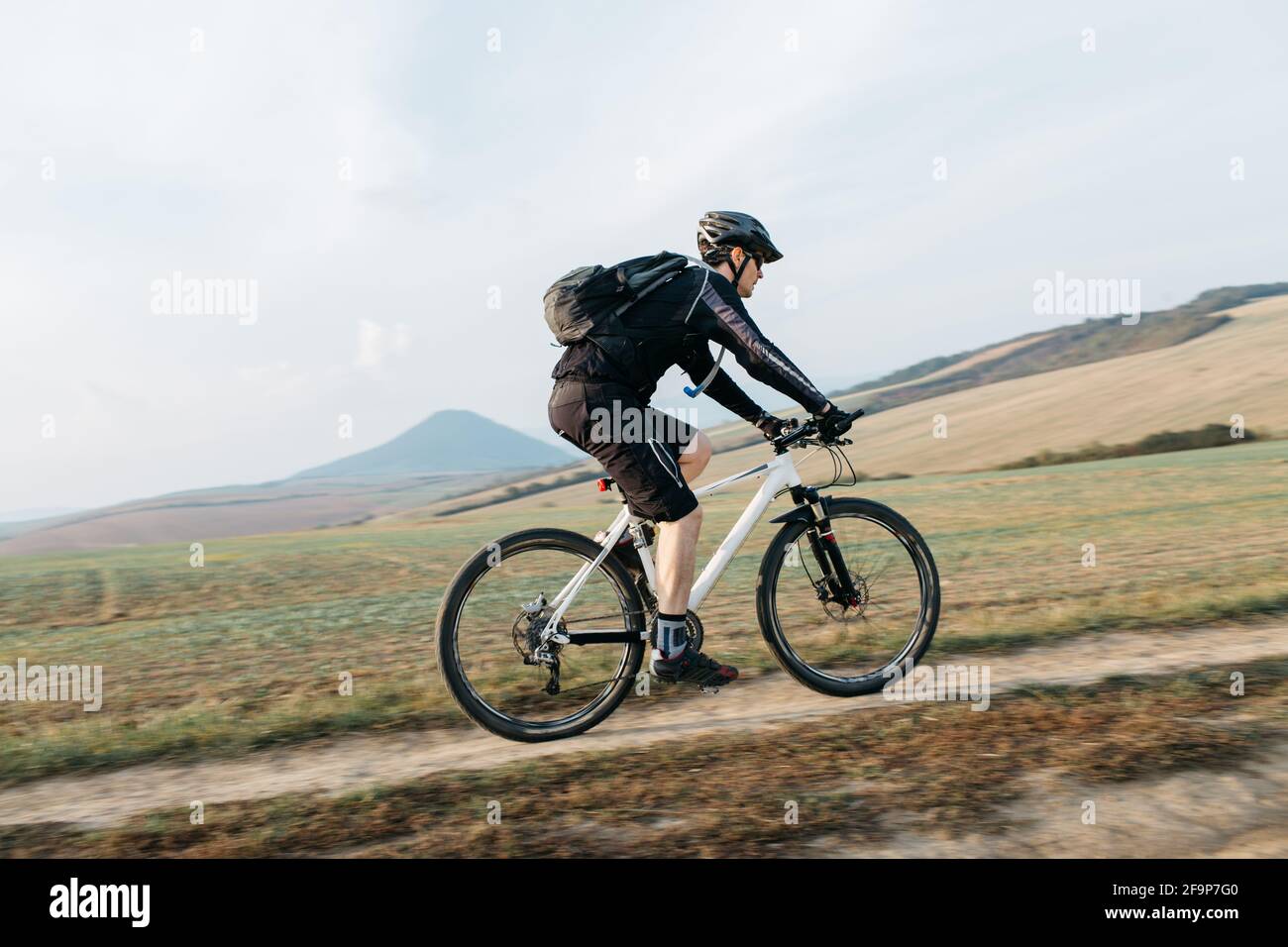 Uomo mountain bike su pista sterrata. Bicicletta ciclistica lungo la strada  sterrata in una giornata di sole Foto stock - Alamy