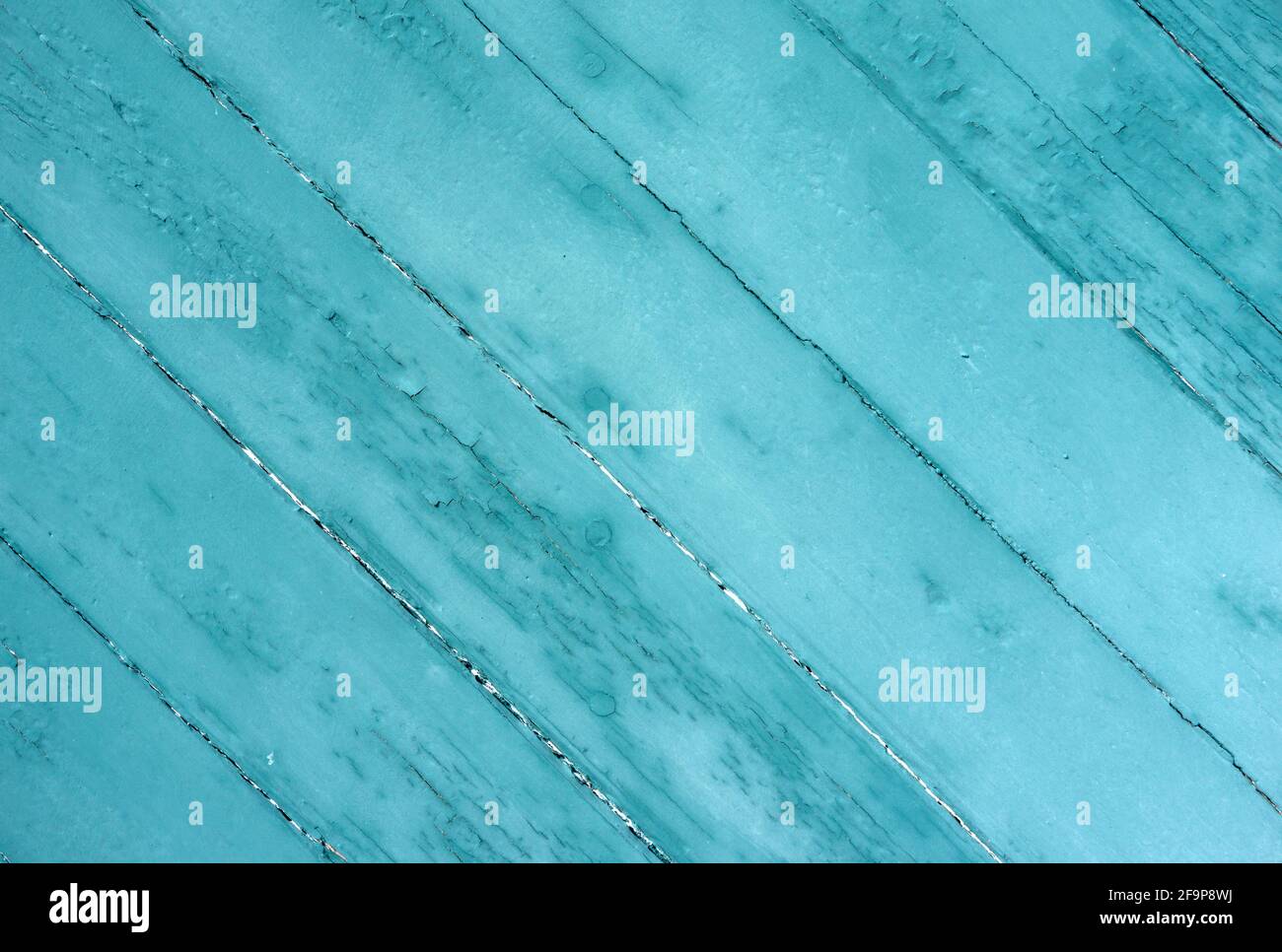 Vecchie tavole ad un angolo verniciato verde sbiadire dalla luce del sole e dalle condizioni atmosferiche. Foto Stock