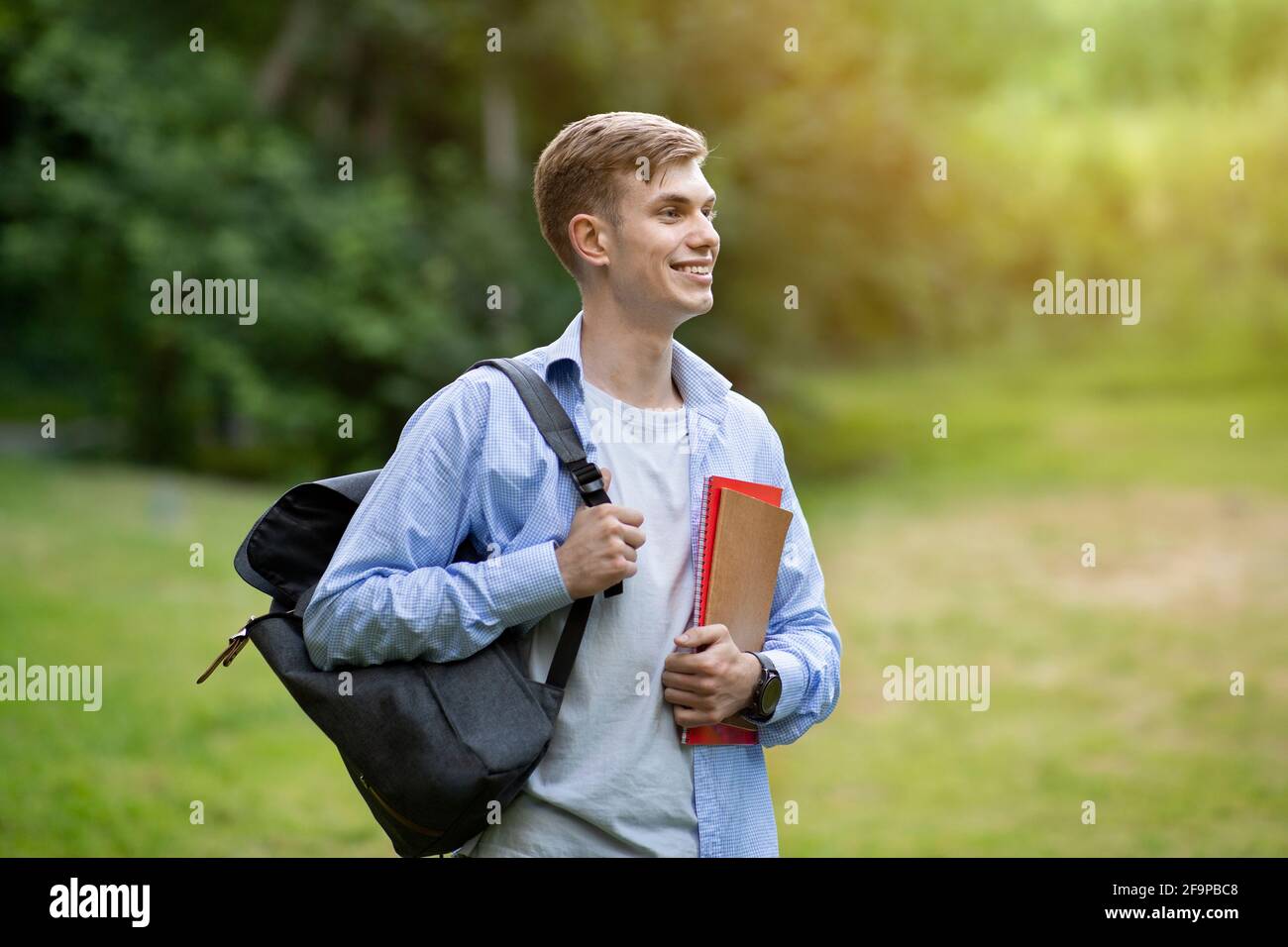 Ritratto esterno di ragazzo studente attraente teen con zaino e. cartelle di lavoro Foto Stock