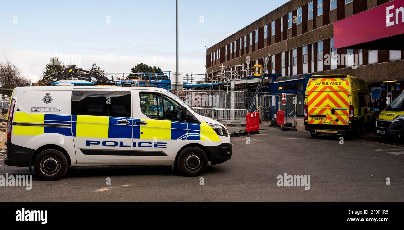 Un pulmino di polizia parcheggiato tra le ambulanze del Diana Princess of Wales Hospital, Grimsby, che mostra i nostri servizi in prima linea in questa pandemia Foto Stock