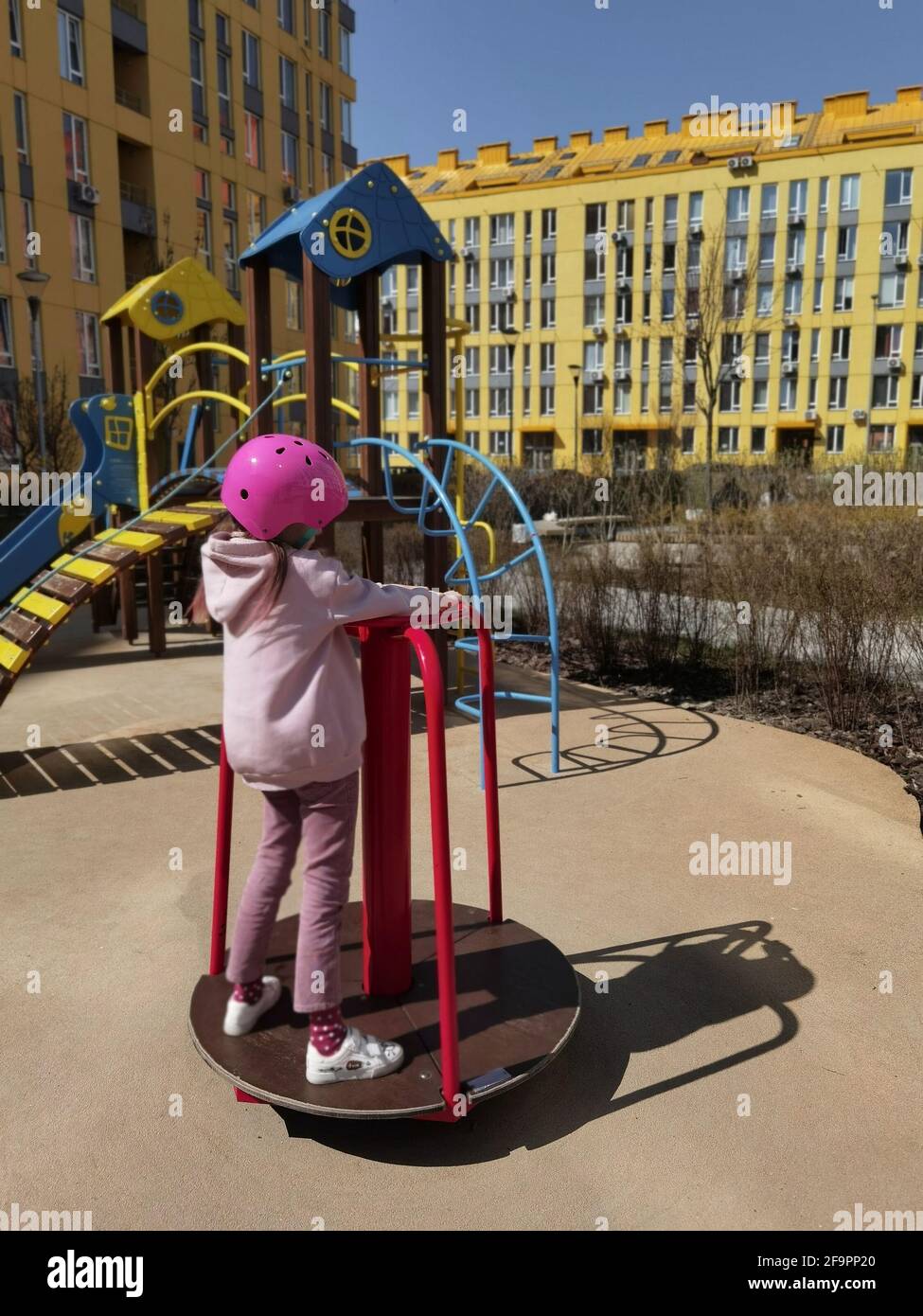 Una ragazza di otto anni in casco a cavallo sulla giostra. Bambino in giostra Foto Stock