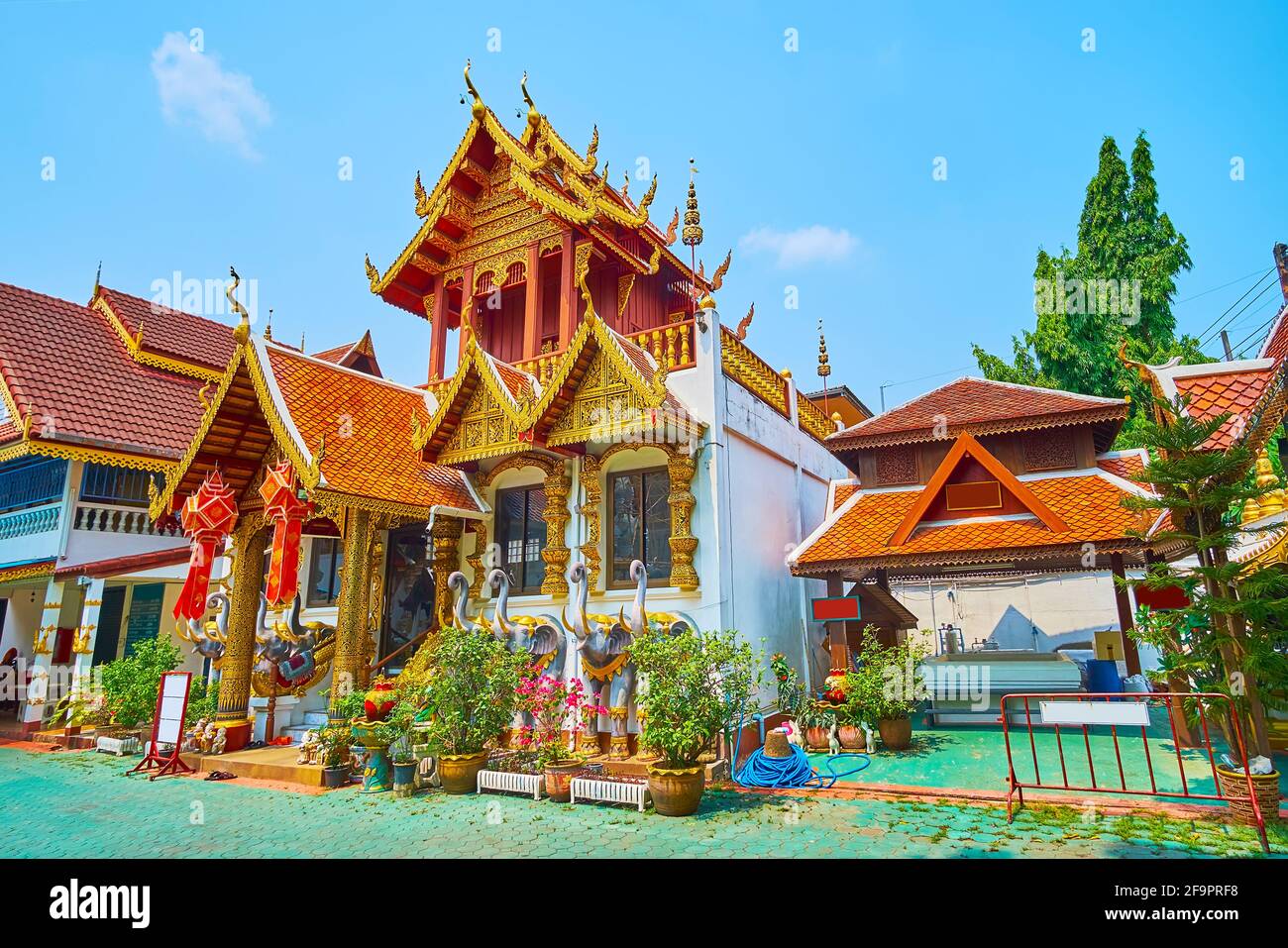 Il pittoresco Ubosot dello storico Tempio di Wat Klang Wiang, decorato con tavolette dorate intagliate, colonne, tetto a timpano, sculture di elefanti, Chiang Ra Foto Stock