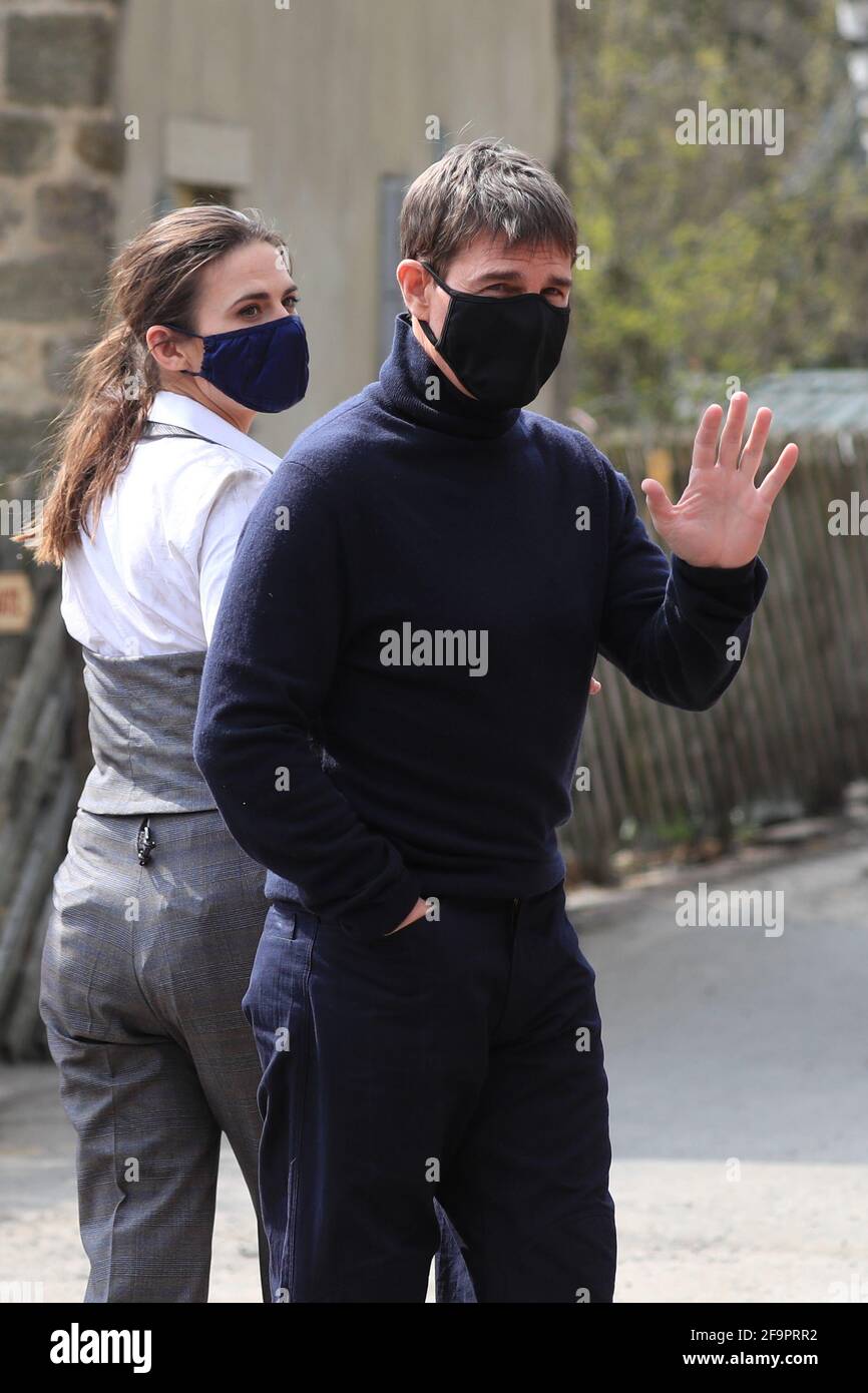 L'attore Tom Cruise ondeggia agli onlookers mentre cammina verso il set del suo ultimo progetto, che sta filmando ai sidi della stazione ferroviaria nel villaggio di Levisham nei Moors di North York. Data immagine: Martedì 20 aprile 2021. Foto Stock