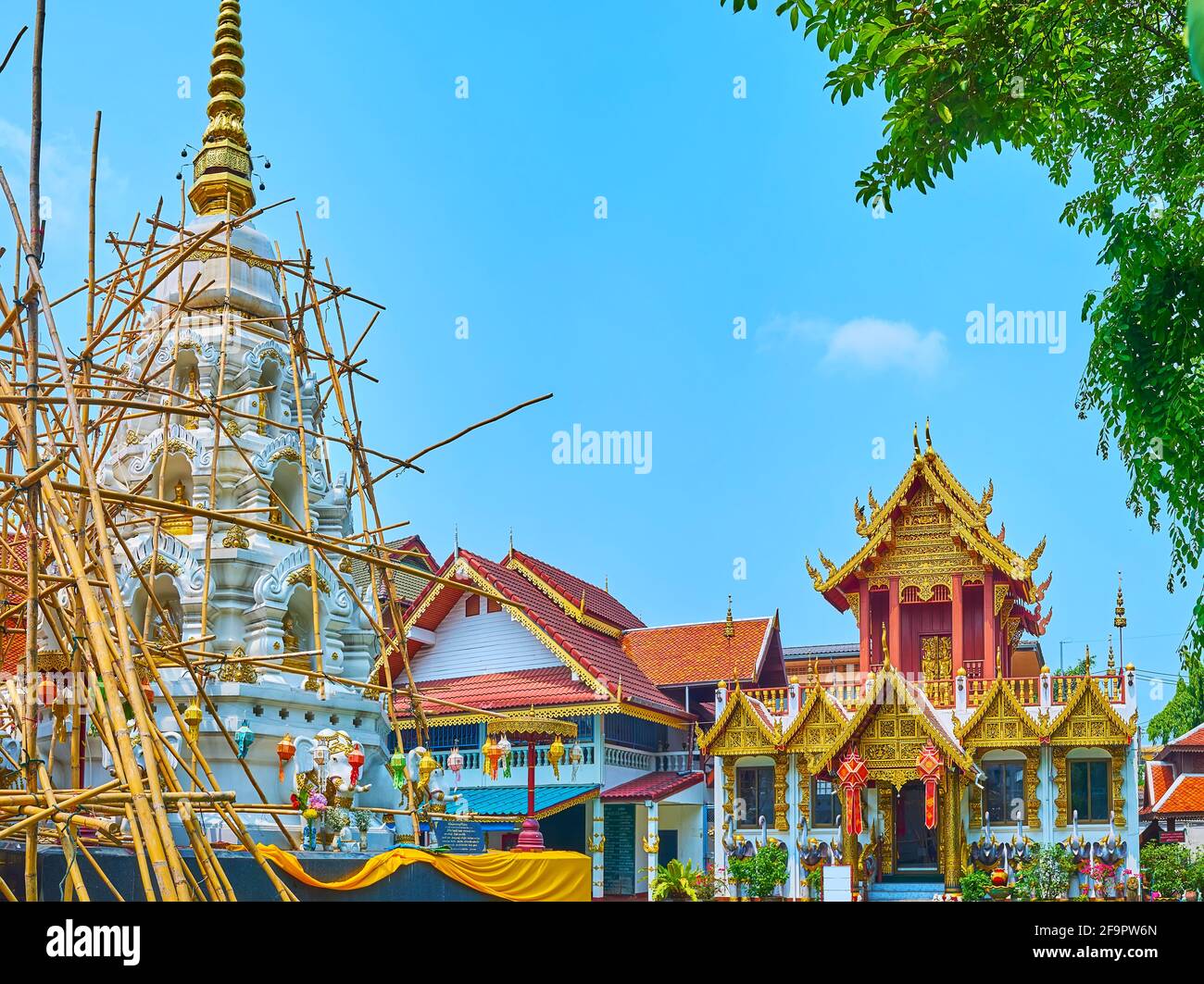 Il Chedi bianco scenico e l'Ubosot ornato (sala di ordinazione) del Wat Klang Wiang, Chiang Rai, Thailandia Foto Stock